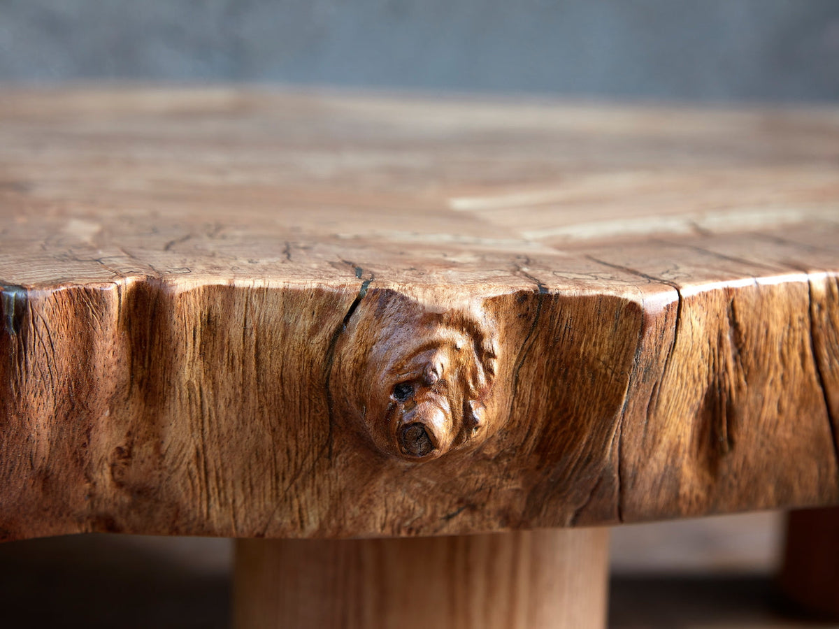 Live-edge spalted beech coffee table detail showing natural knot, grain texture, and solid wood edge.