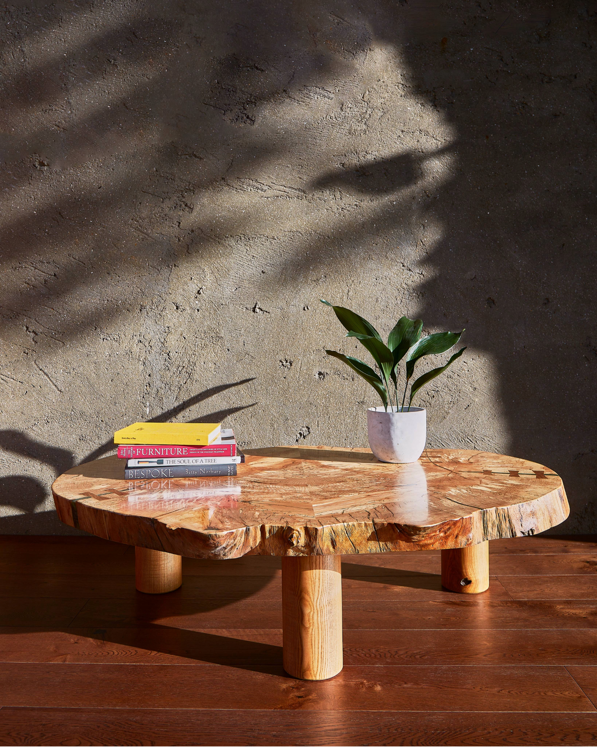 The Cocoon live edge coffee table displayed on a clean minimalist background, highlighting its spalted beech wood top and cylindrical ash legs.