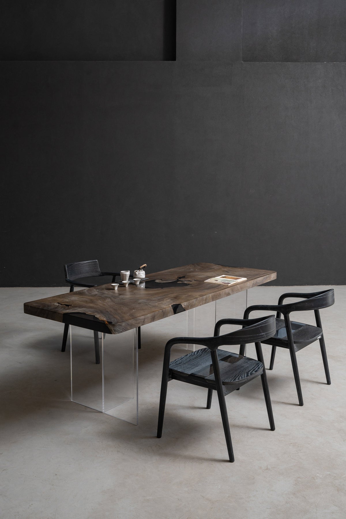 In-situ view of Basin Meridian live-edge rainwood table, natural slab shape, warm brown tones, and organic grain.