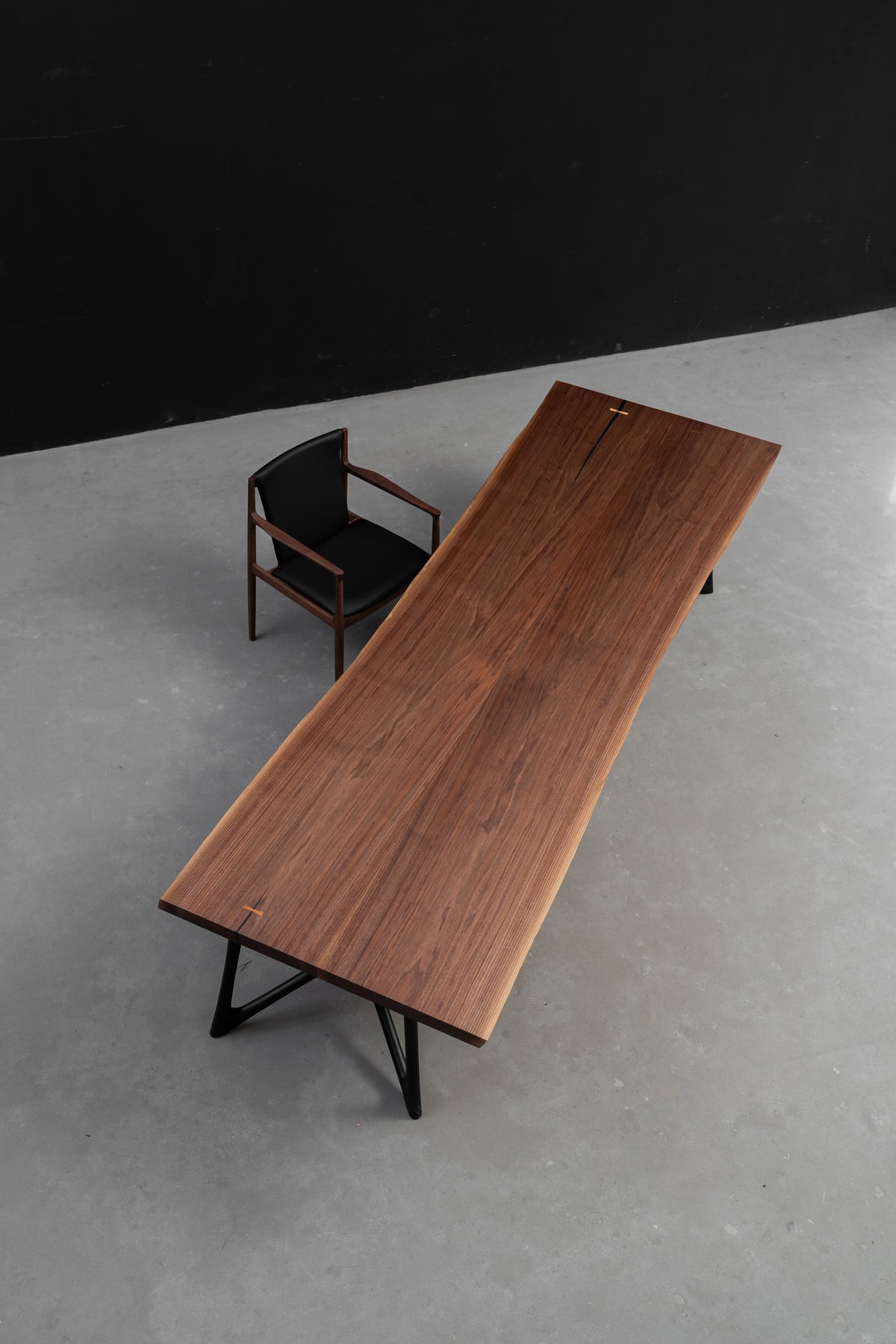 High-angle perspective of the 3.2m Duskwood Bridge live edge walnut dining table, with Woodslabs' Butterfly Effect black base.