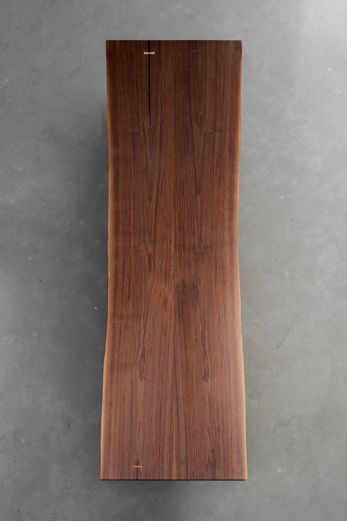 Woodslabs presents a vertical overhead shot of the 320cm Duskwood Bridge, showcasing the cathedral grain patterns of black walnut.