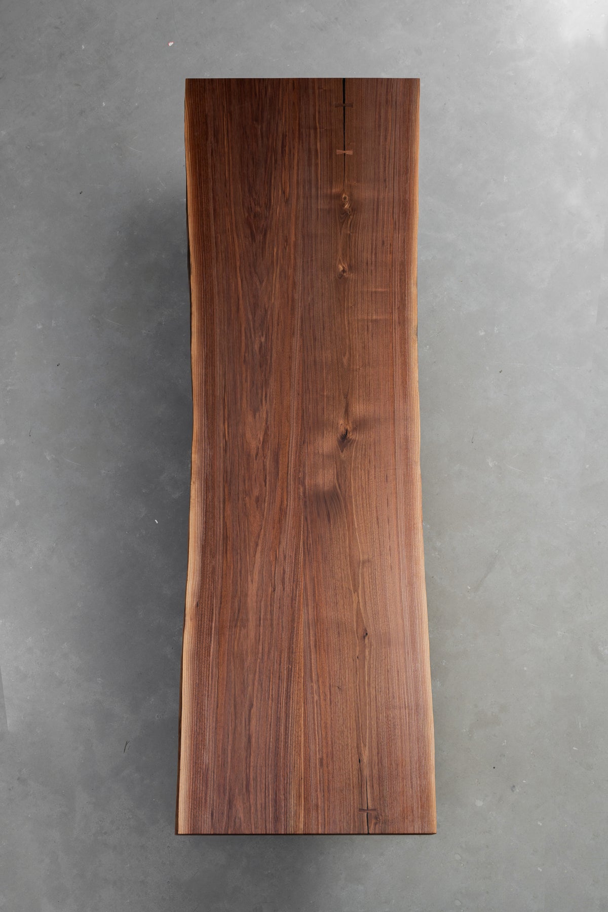 Detailed overhead view focused on the underside symmetry oil finish of the live edge slab.