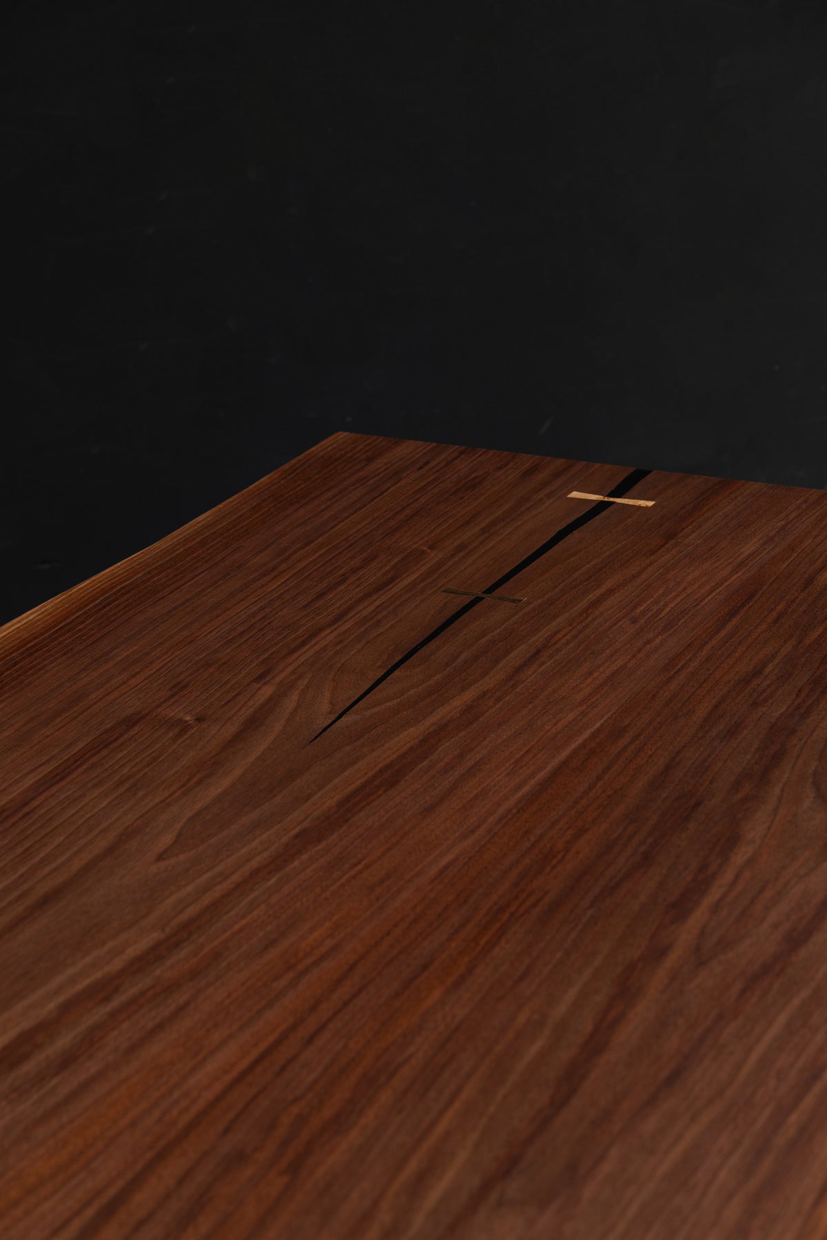Close-up detail of the black walnut live edge table by Woodslabs. Featuring deep brown tones of grain and artisan joinery.