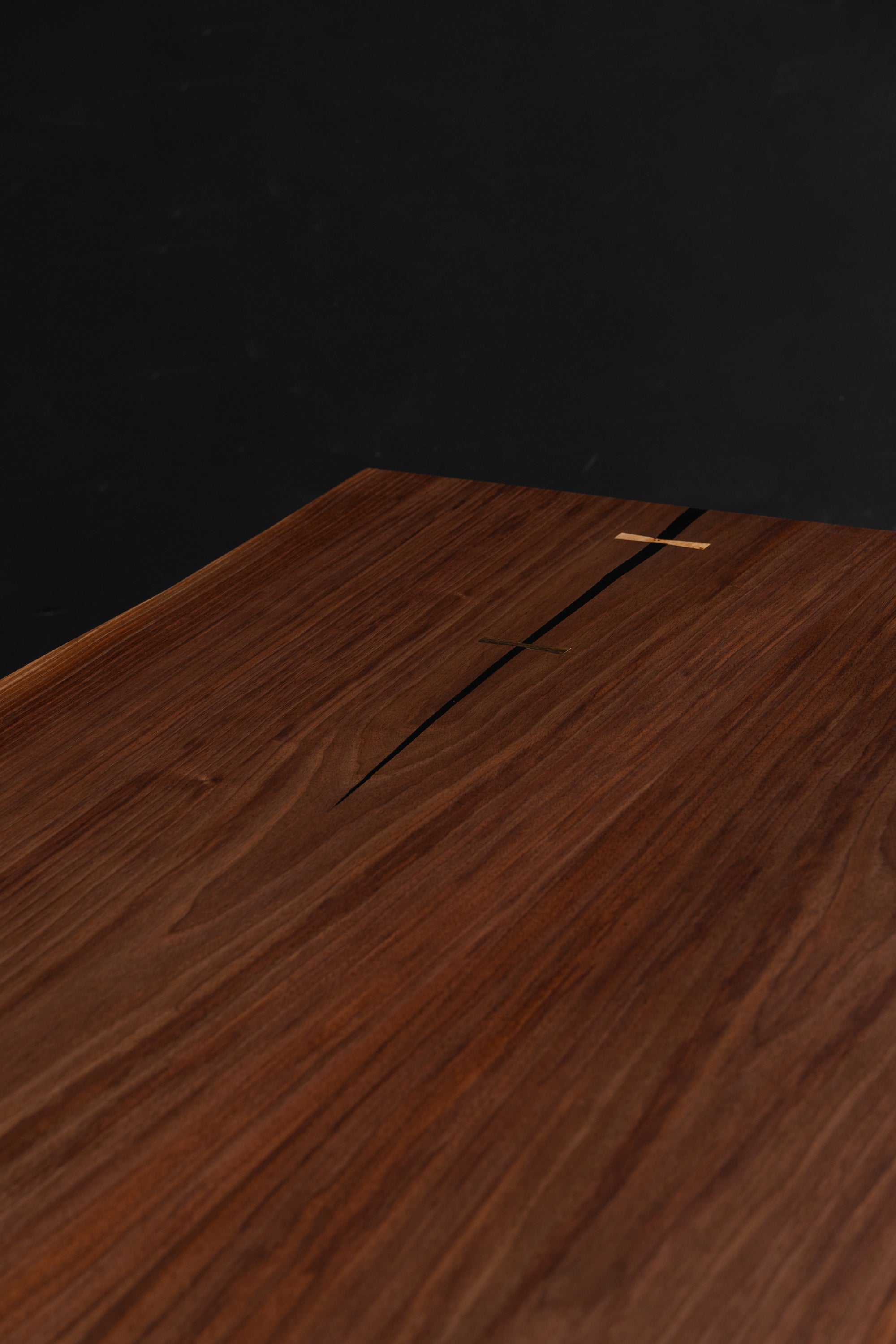 Close-up detail of the black walnut live edge table by Woodslabs. Featuring deep brown tones of grain and artisan joinery.