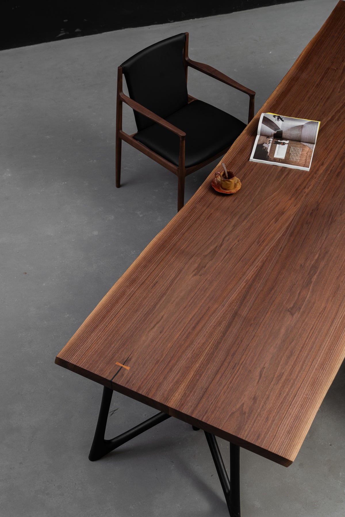 Perspective shot from the head of the table highlighting black walnut grain, artisanal joinery and live edge by Woodslabs.