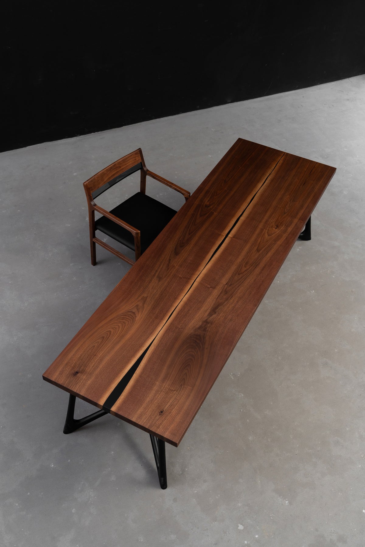 Top-down view of the premium book-matched walnut table united by a minimalist resin stream inlay, by Woodslabs