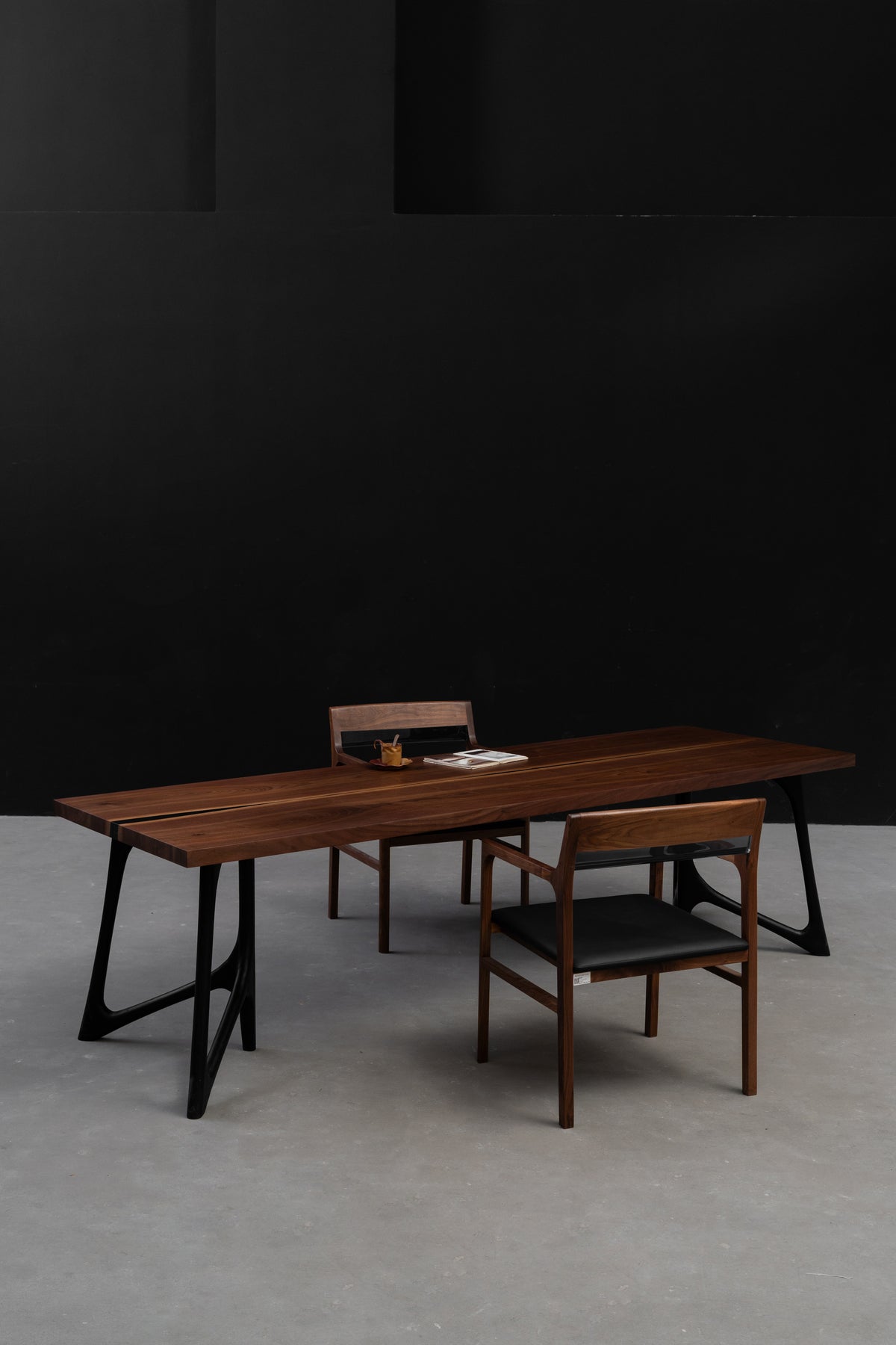 In-situ minimalist setting showcasing the Duskwood Vault table in black walnut wood, by Woodslabs