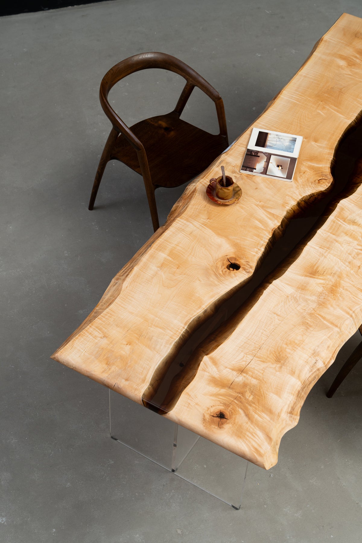 Woodslabs Japanese Tochi live-edge table with central earth-tone resin river, angled overhead perspective