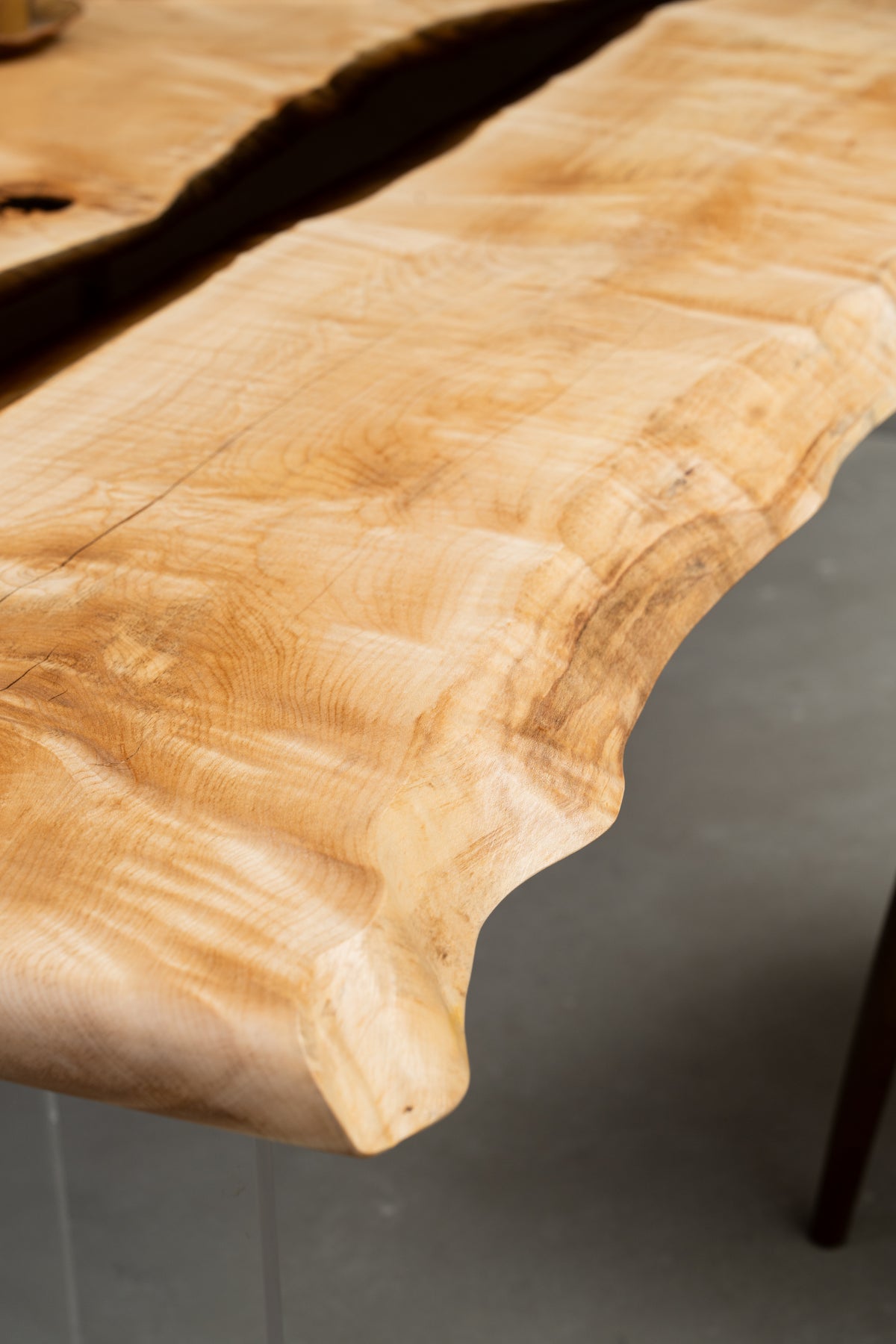 Detailed view of Japanese Tochi live edge with smooth resin integration and natural texture