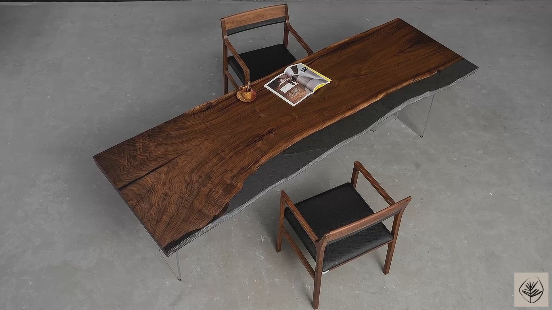 Full table overview of black walnut live edge table with resin feature on transparent resin legs in studio setting