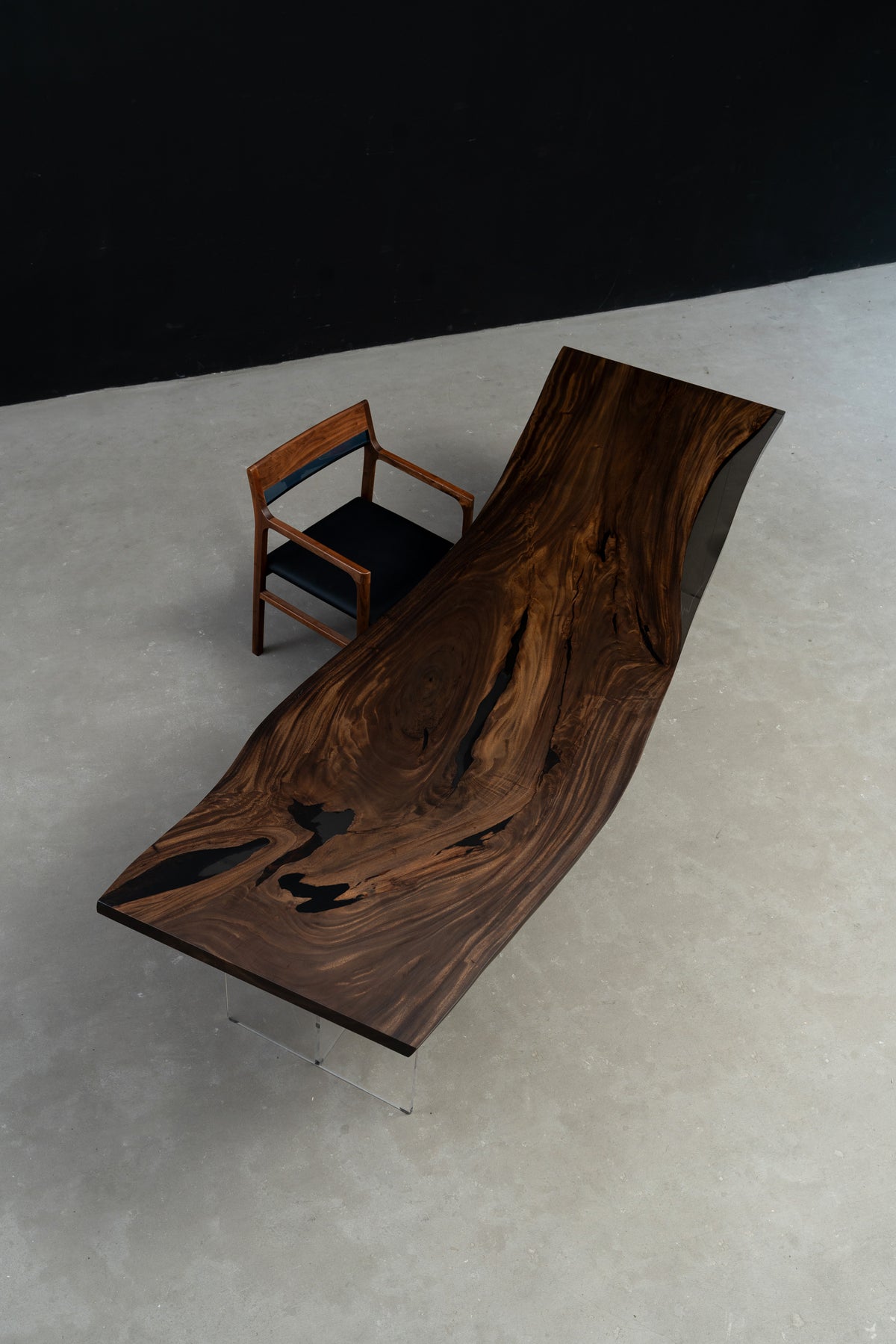 Rainfall Meridian live edge rainwood dining table with translucent black epoxy resin, sculptural curved slab design