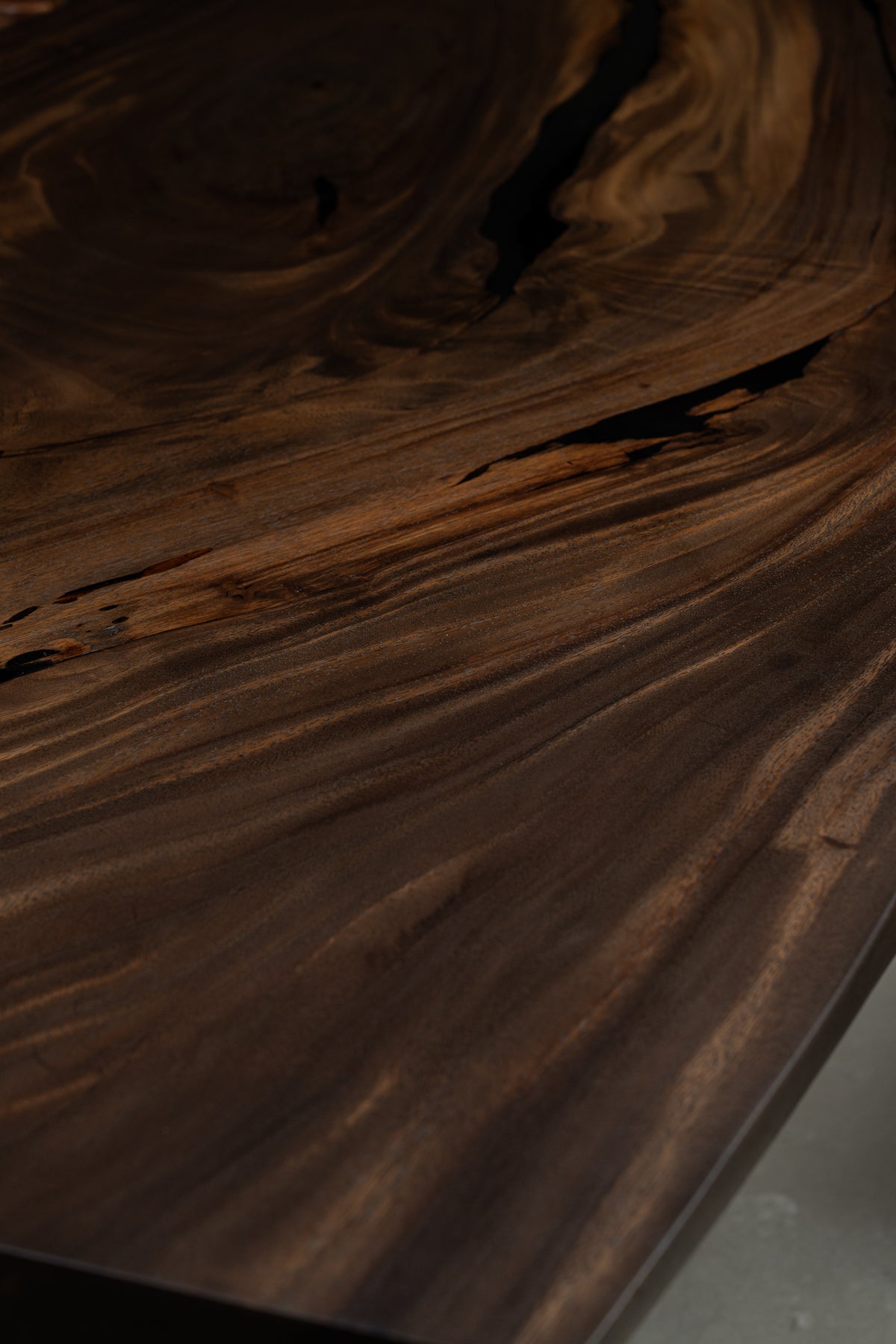 Close-up of Rainfall Meridian rainwood tabletop showing deep flowing grain and natural surface texture