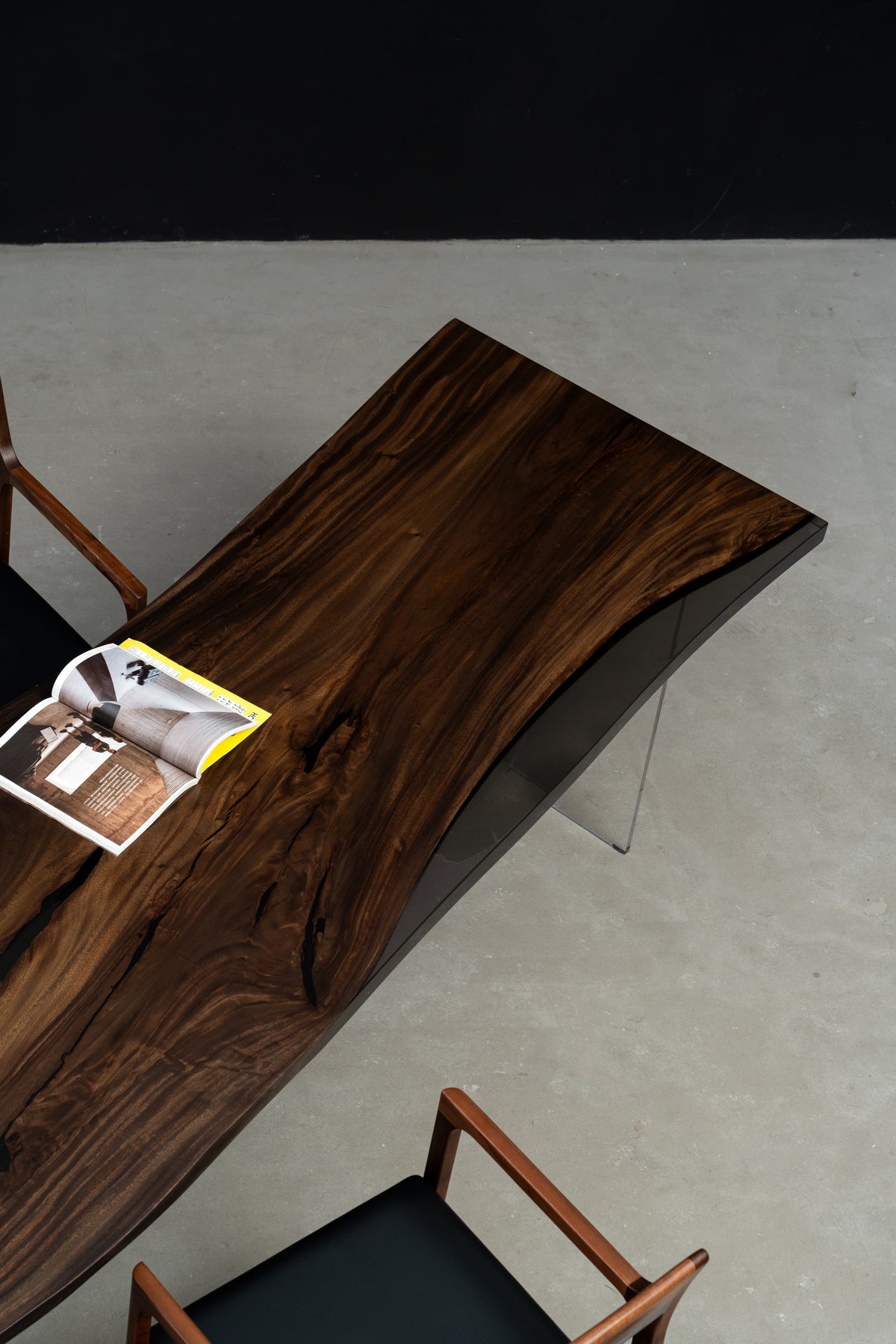 Three-quarter view of Rainfall Meridian live-edge rainwood dining table with flowing grain and black translucent resin