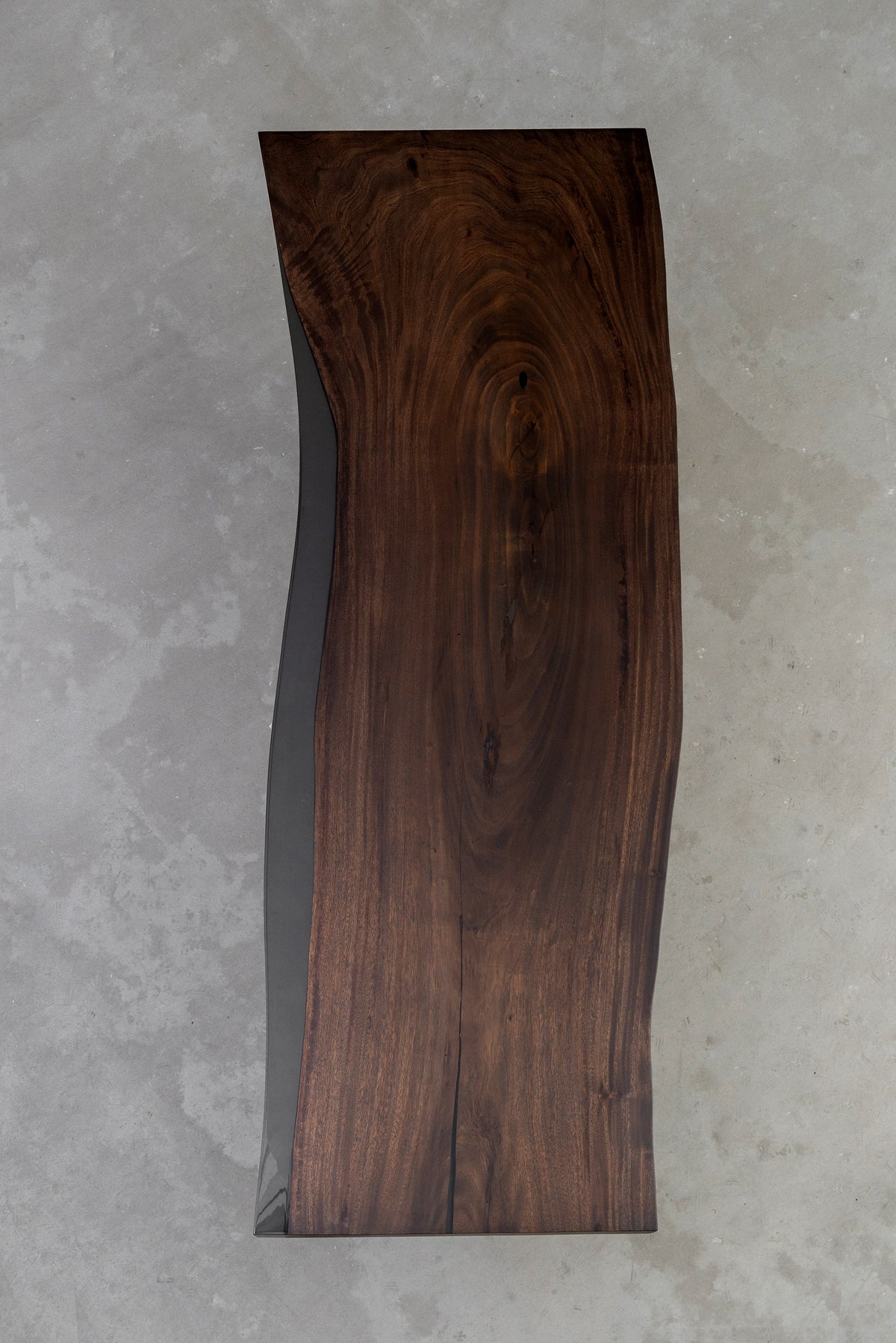 Top-down view of live-edge rainwood table showing flowing grain and subtle translucent resin edge