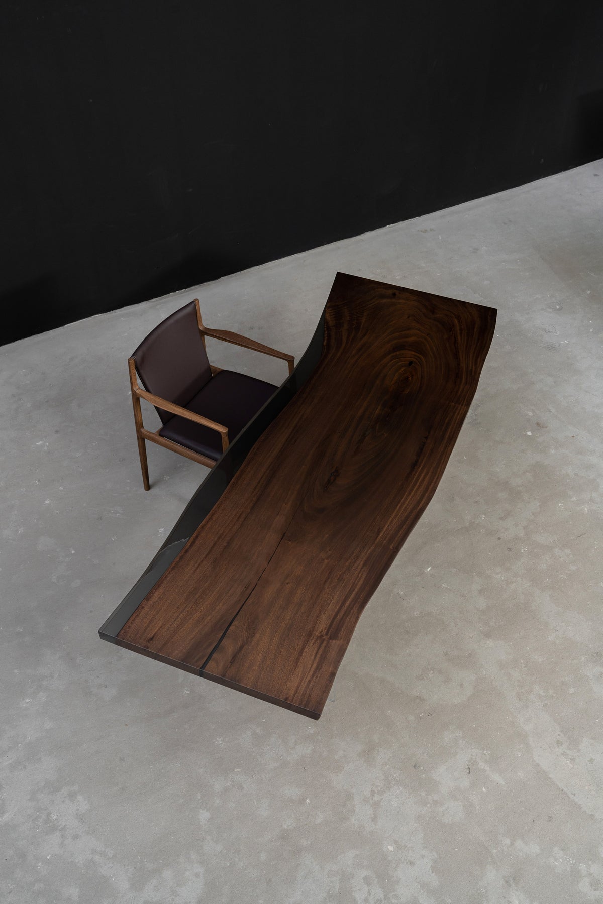 Overhead view of Meridian Shores rainwood dining table with smooth live edges and translucent black resin detailing