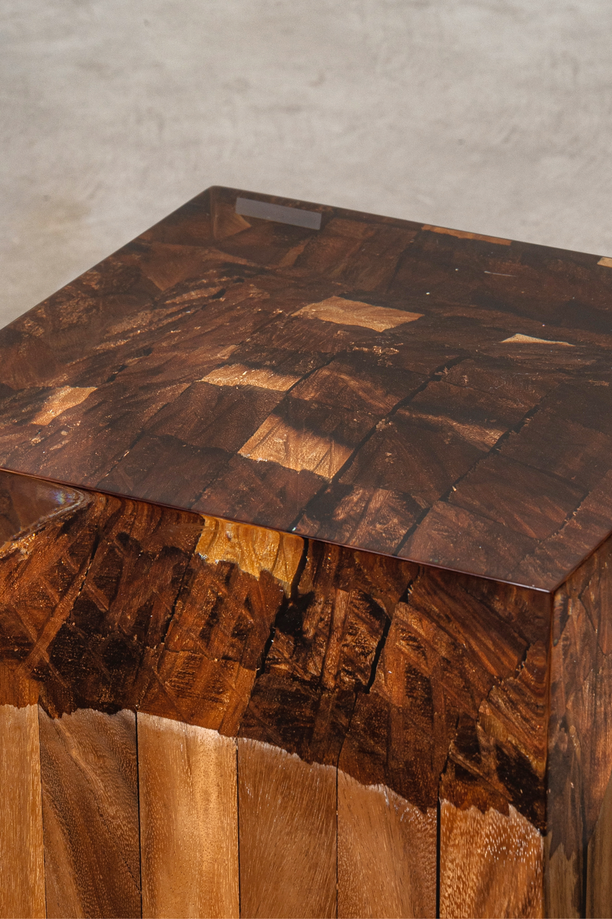 Close-up view of the Cube of Origins, showing epoxy resin encasement around natural wood burl grain and textures.