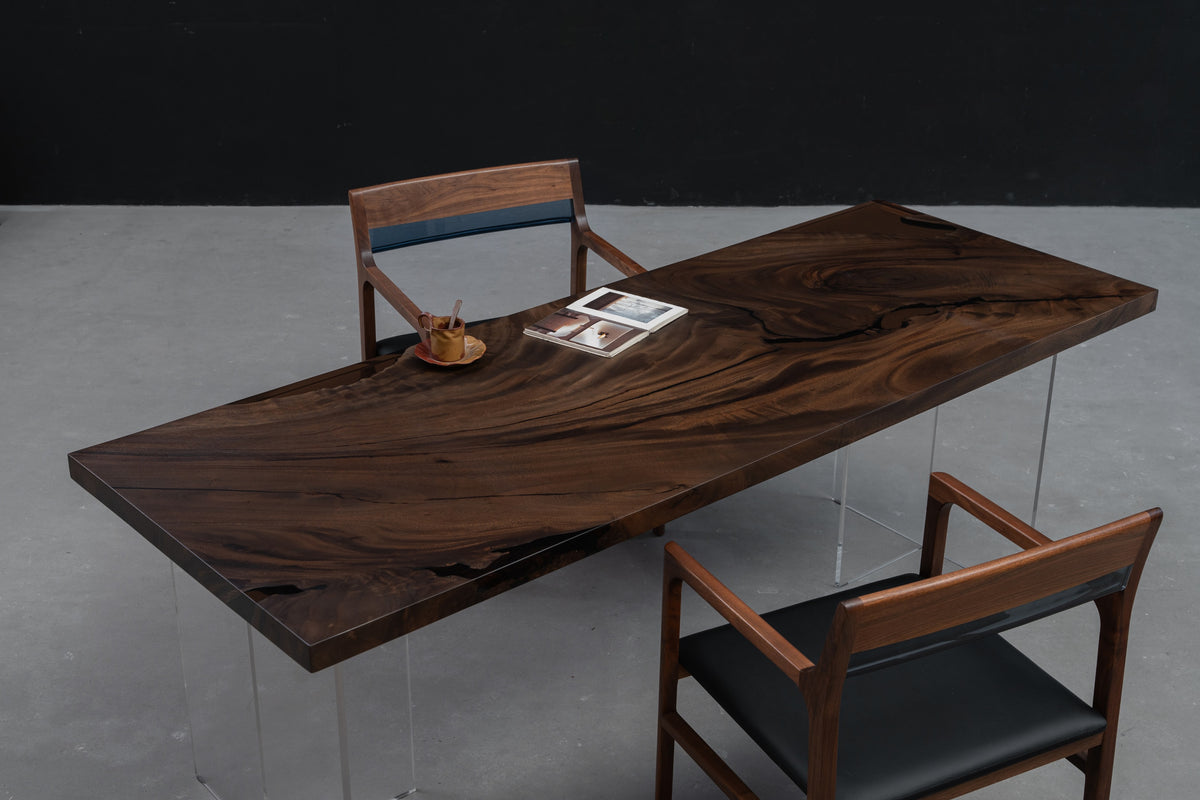 Meridian South Current rainwood dining table with live edges, shown from an angled wide view highlighting proportions and grain.