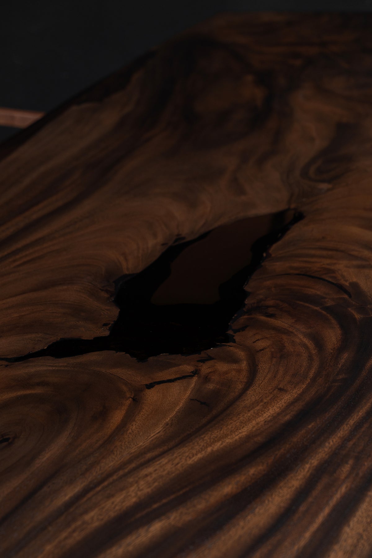 Epoxy resin detail of the Southern Lines Meridian table showing natural live-edge contour and refined surface finish.