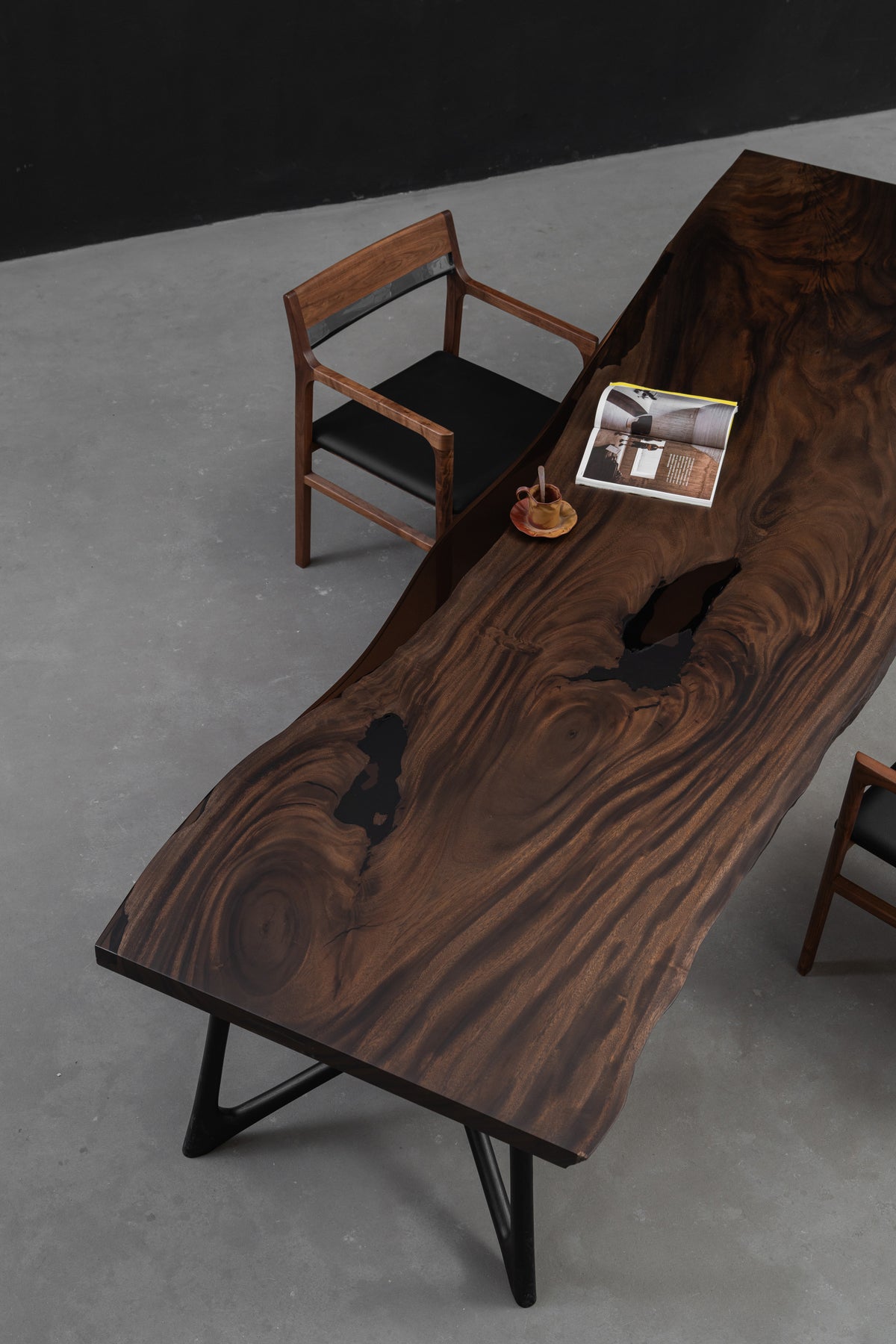 Three-quarter angle of the Southern Lines Meridian live-edge rainwood slab table, showing thickness, and grain.