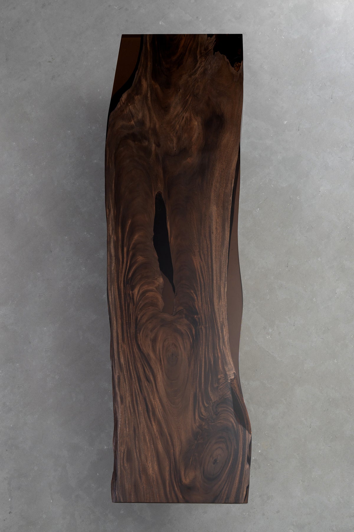 Vertical slab Southern Lines Meridian rainwood table highlighting natural edge profile underside view.