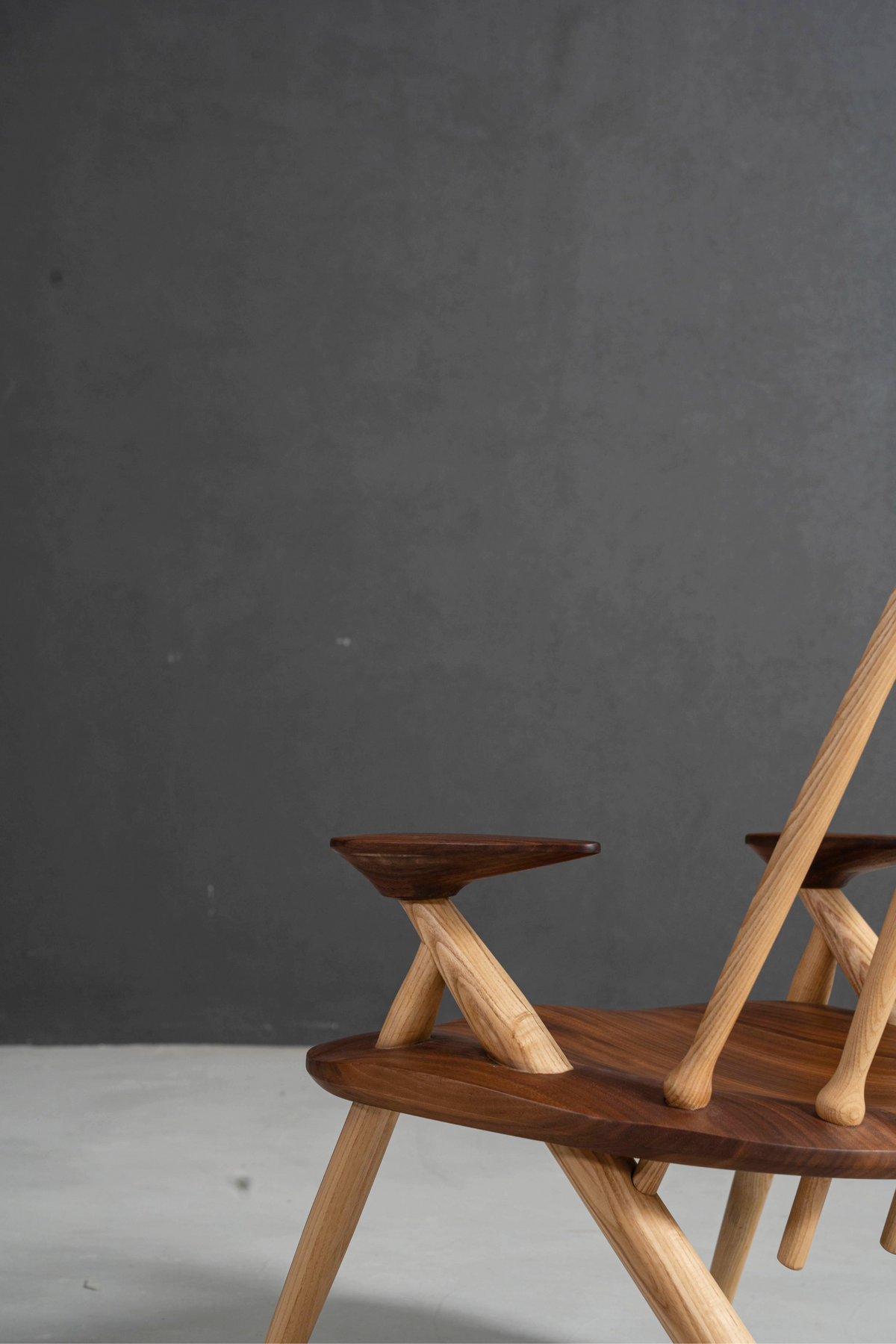 Detailed view of Arcadia Chair's arm and seat, highlighting contoured wood for comfort.