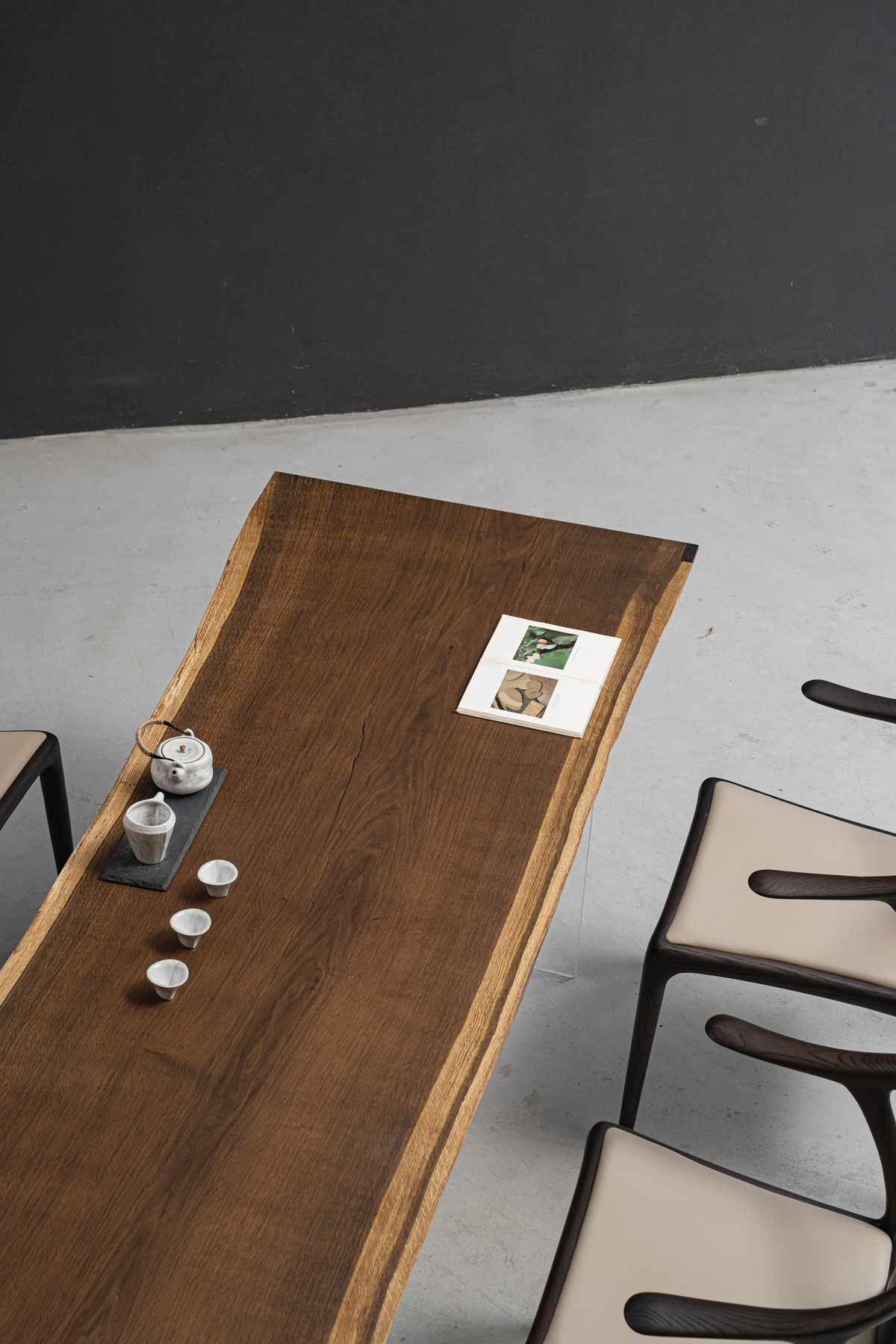 Angled overhead shot of the Aureole Table with chairs in a minimalist setting, showcasing the smoked oak surface.