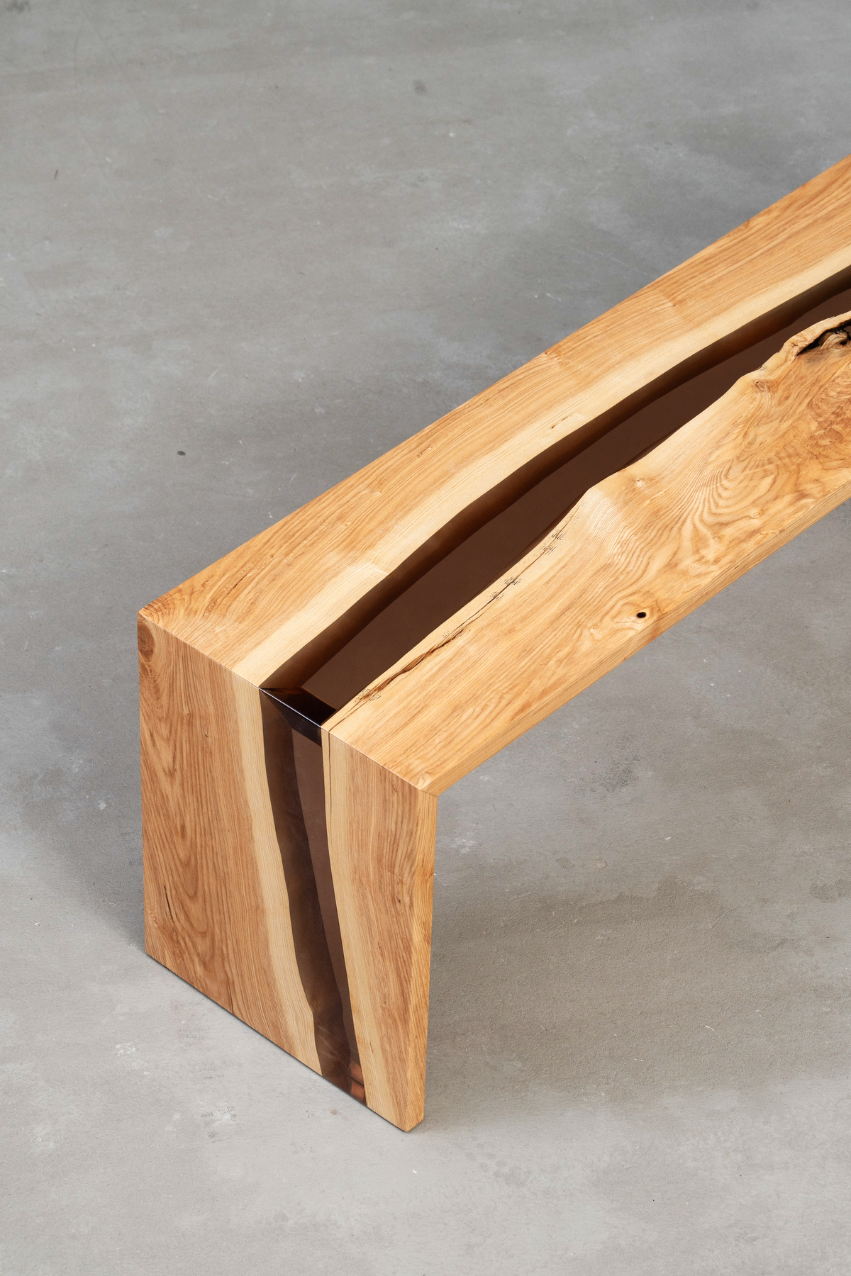 Three-quarter angle perspective highlighting bench edge and seat with flowing resin detail.