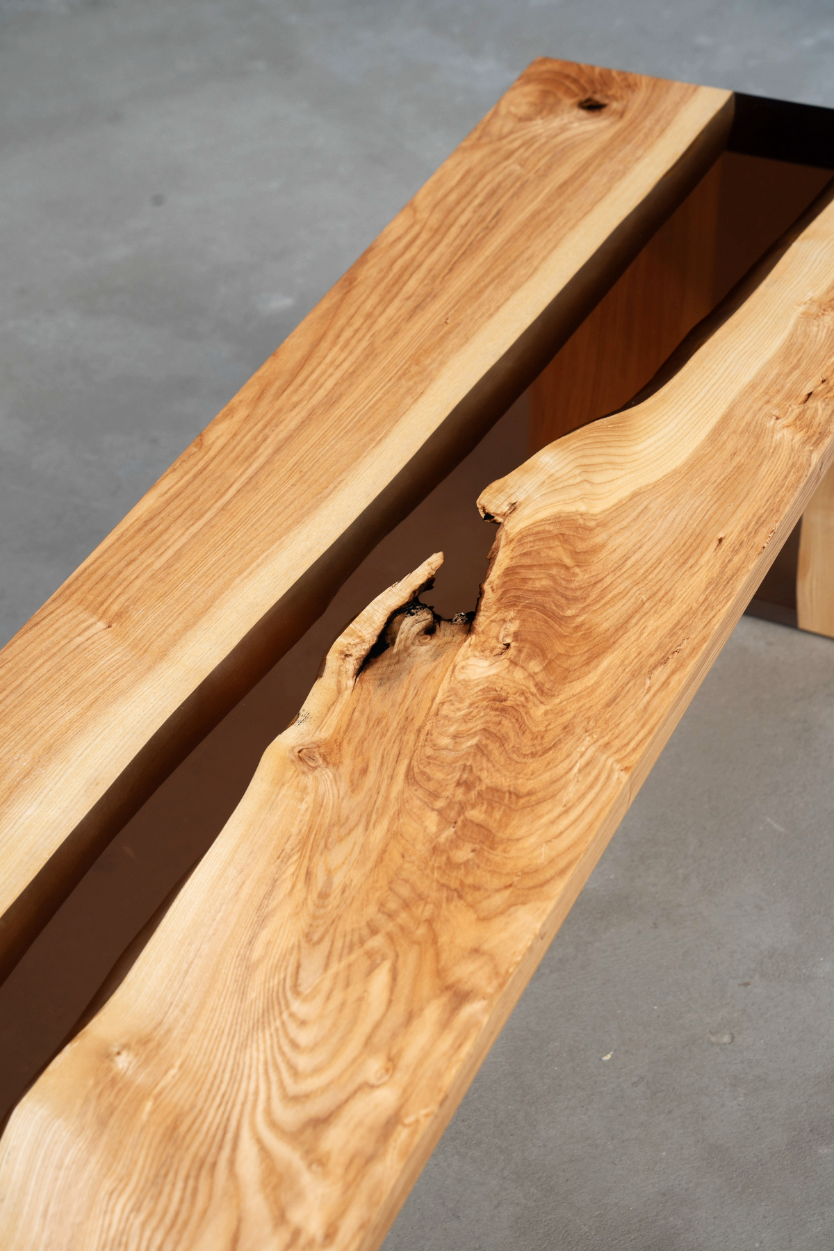 Angled overhead view of Bridge of Stillness Bench showing epoxy river and wood contours.