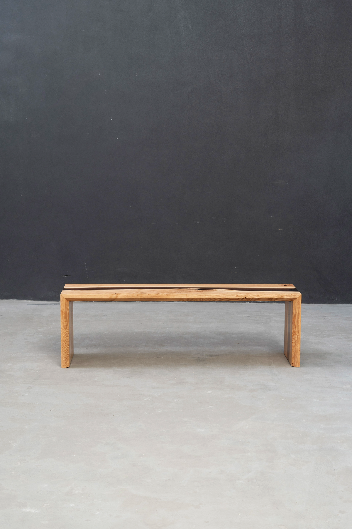 Front perspective of bench showcasing clean lines and epoxy river in minimalist setting.