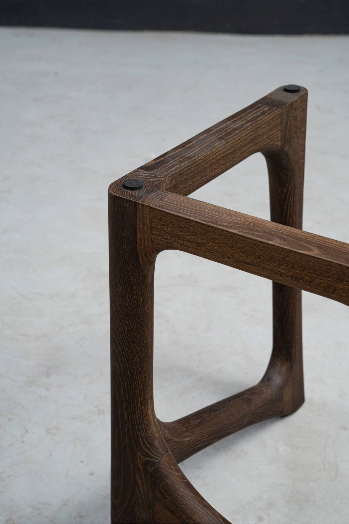 Close-up of smoked oak Butterfly Effect base's top edge, showcasing precise joinery and wood grain.