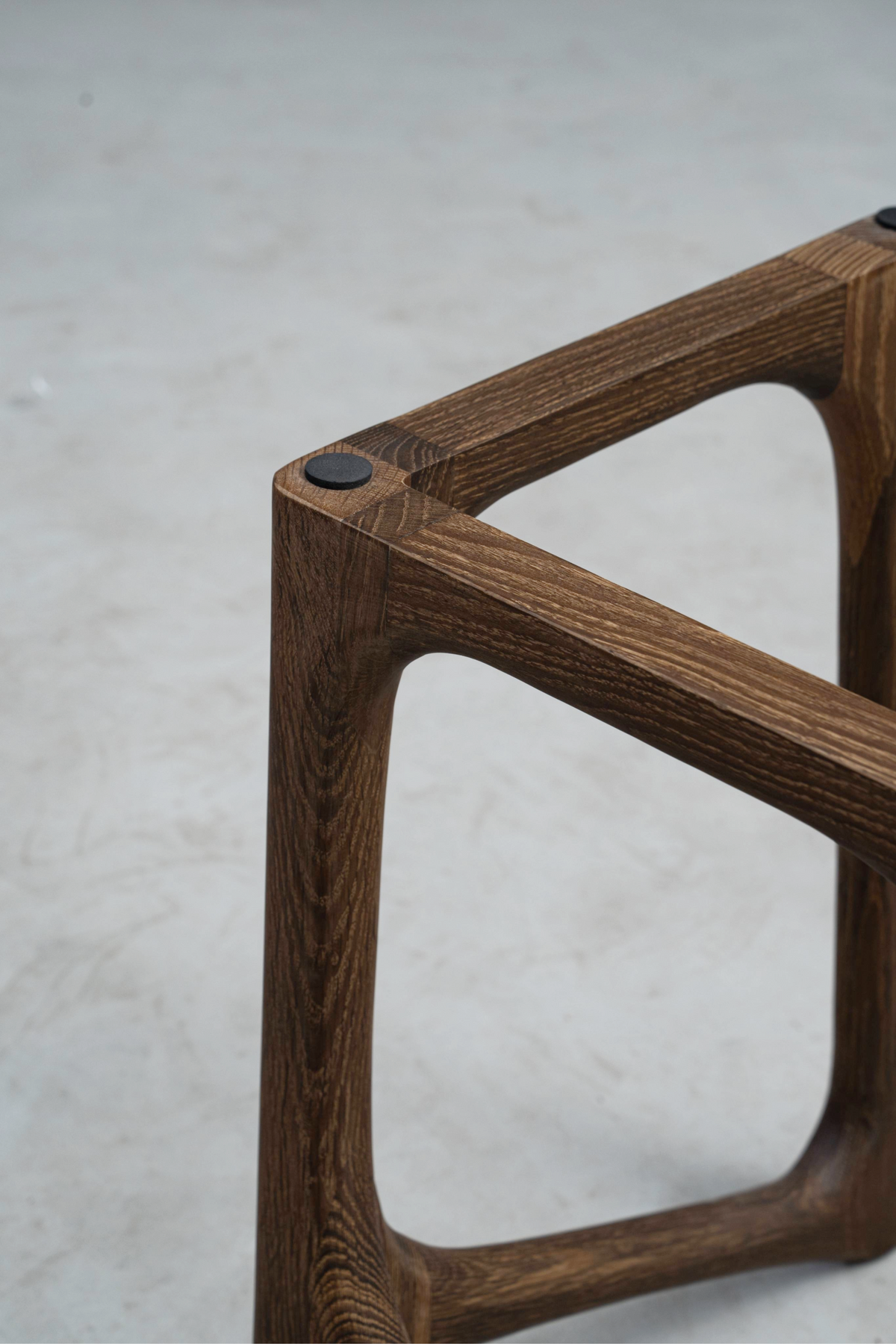 Close-up of the Butterfly Effect base's top edge, showcasing smoked oak craftsmanship and joinery detail.