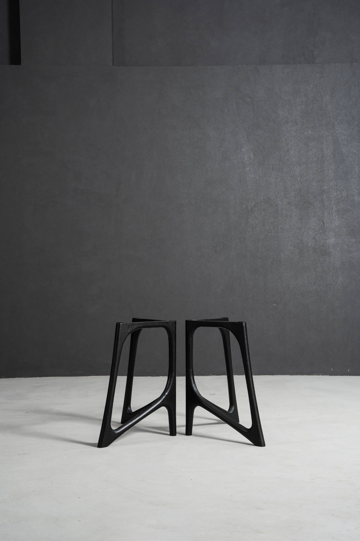 Symmetrical pair of black stained oak Butterfly Effect T-Stands, showcasing the precision joinery and structural design.