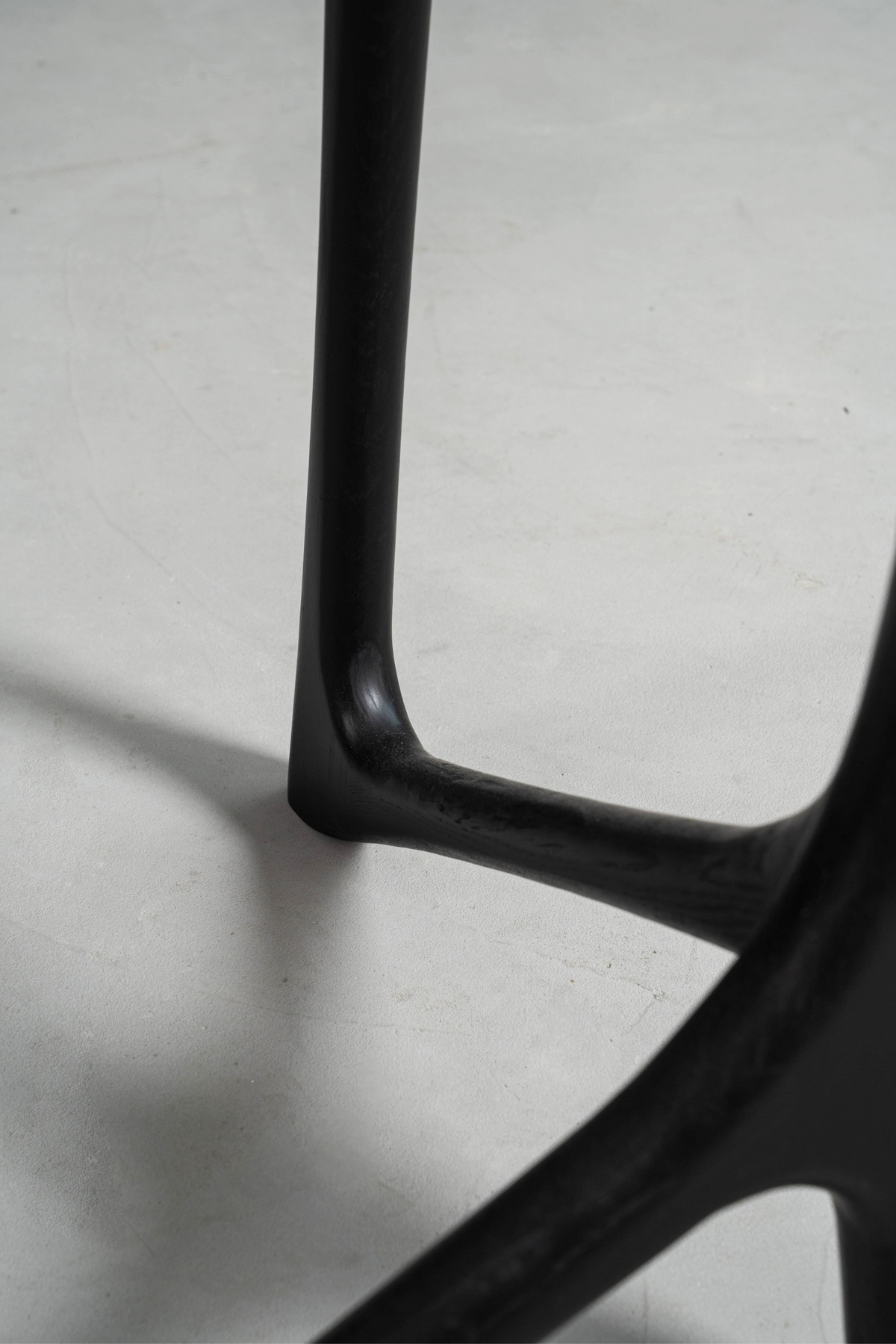 Close-up of a Butterfly Effect T-Base corner ledge, highlighting the black stained oak design and clean joinery.