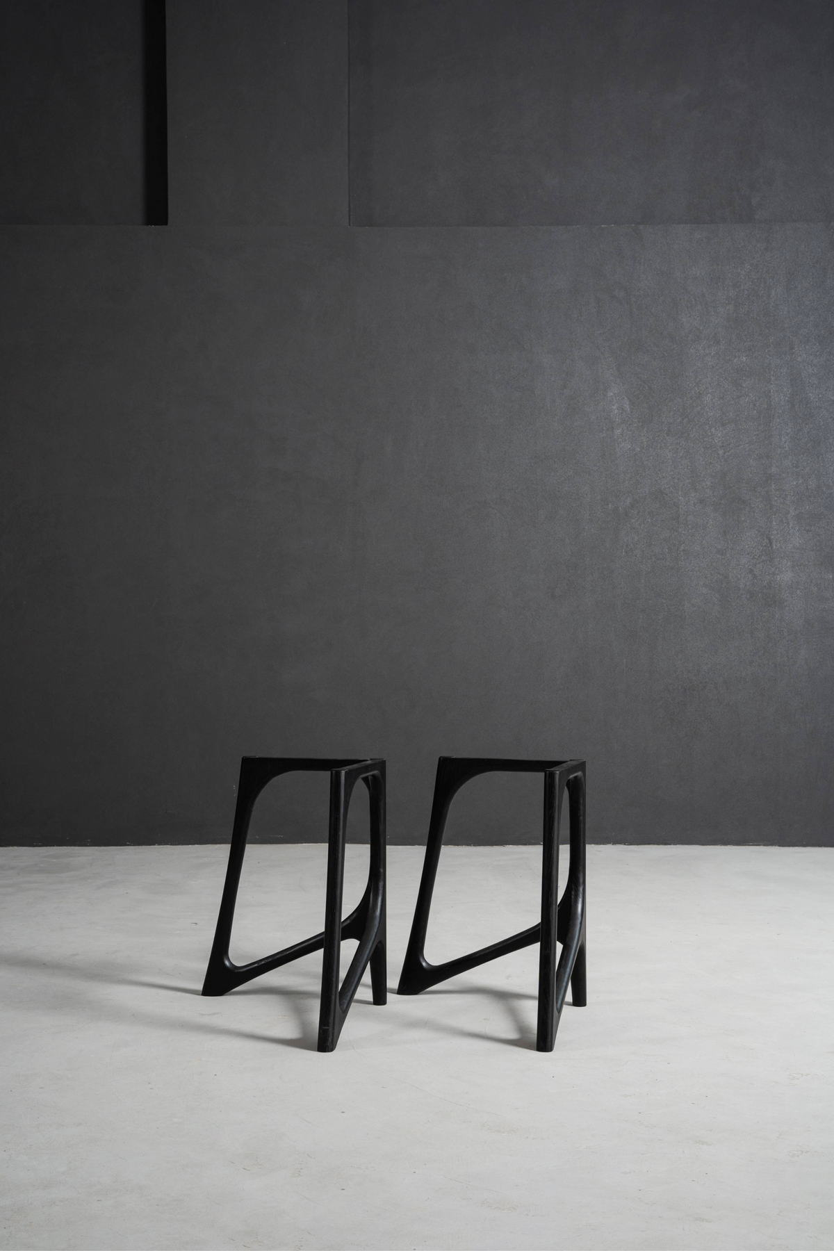 Woodslabs black Butterfly Effect table stands against a minimal concrete background.