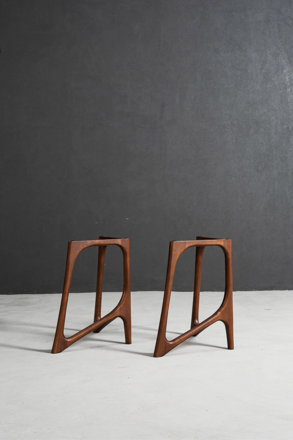 Butterfly Effect V-base table stand in black walnut, sculptural V-shaped support with refined architectural balance.