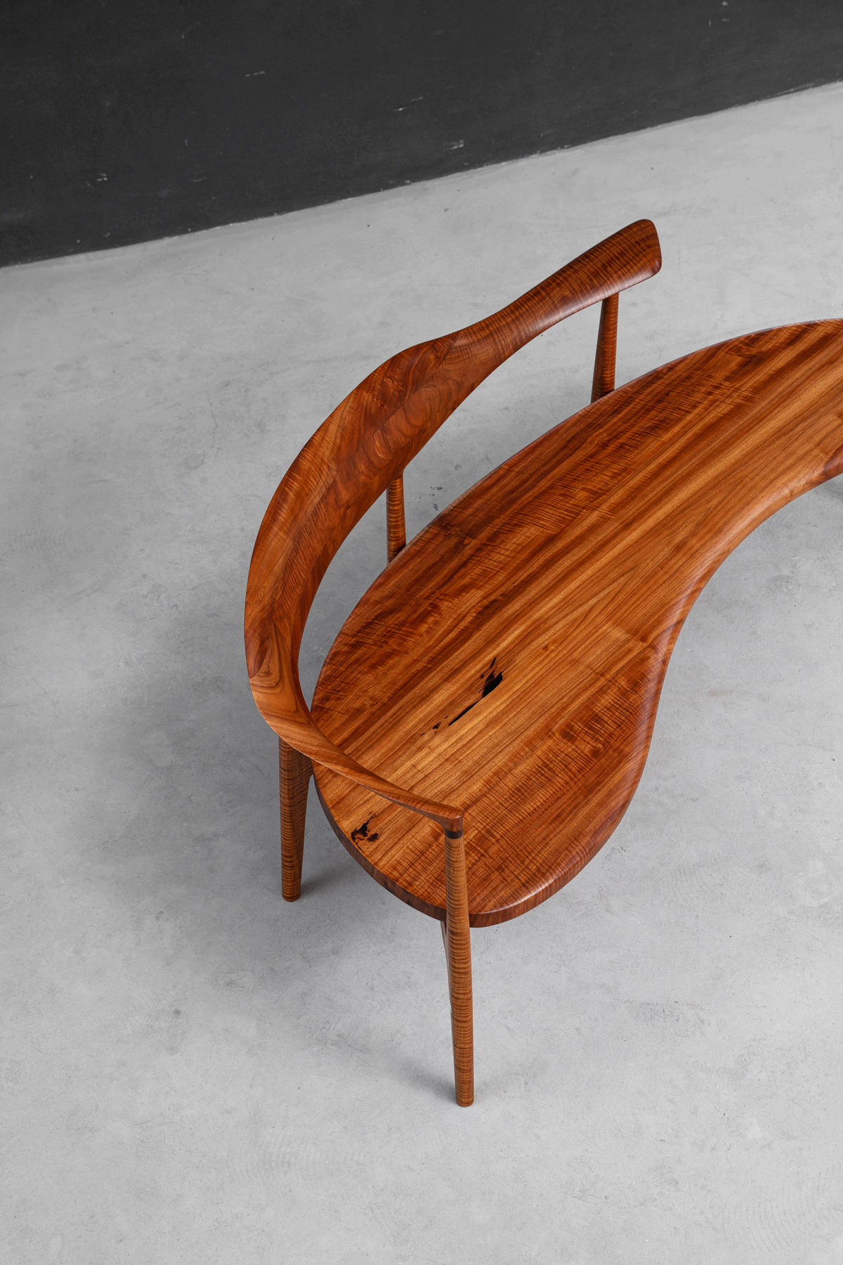 Overhead angle view emphasizing Indian rosewood's dramatic grain in the Confluence Chair's form.