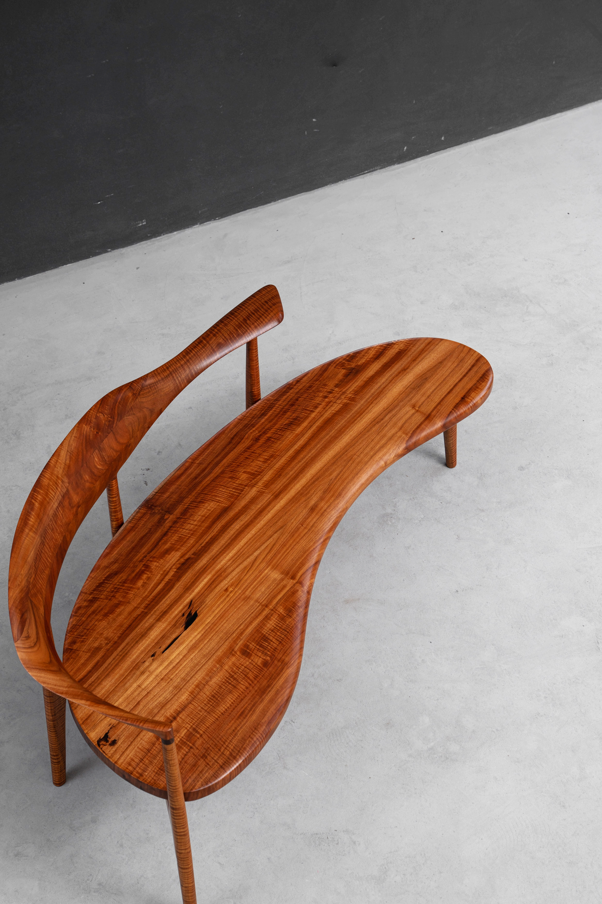 Aerial view of acclaimed Confluence Chair highlighting rosewood's grain and master craft.