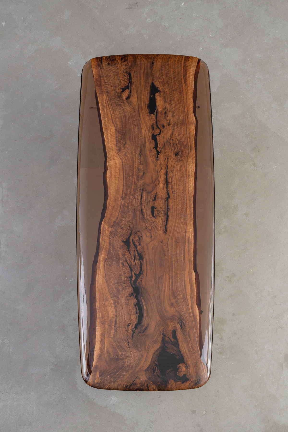 Aerial view of the Continental Table's elegant form: a walnut slab embraced by rounded resin river edges.