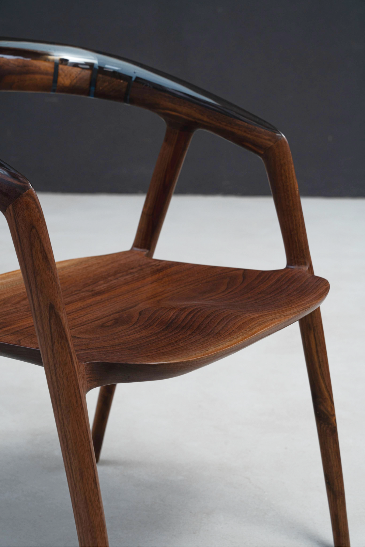 Close-up perspective showing seamless wood-resin harmony on seat and backrest design.