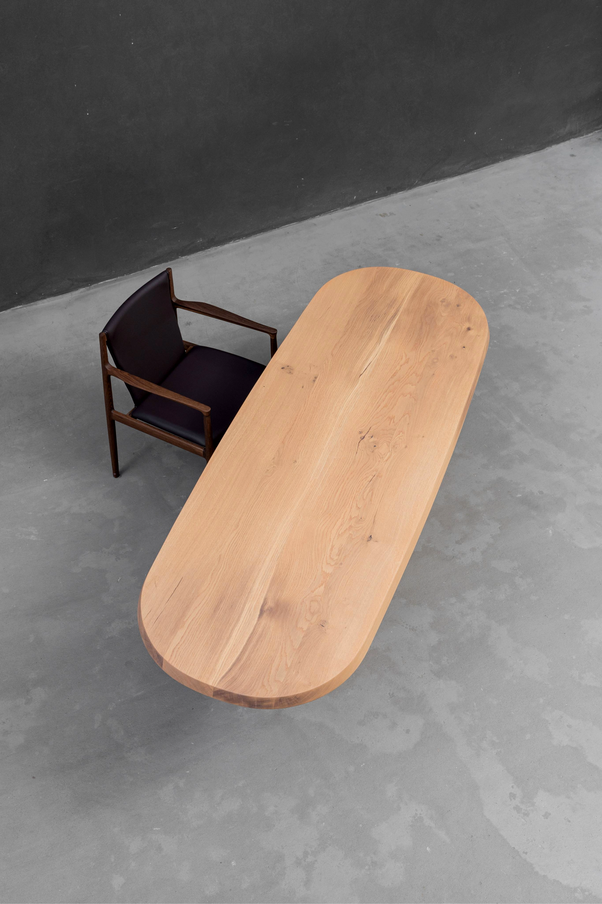 Overhead view of the Fusion Table's white ash wood slab, showcasing its natural grain and stadium profile design.