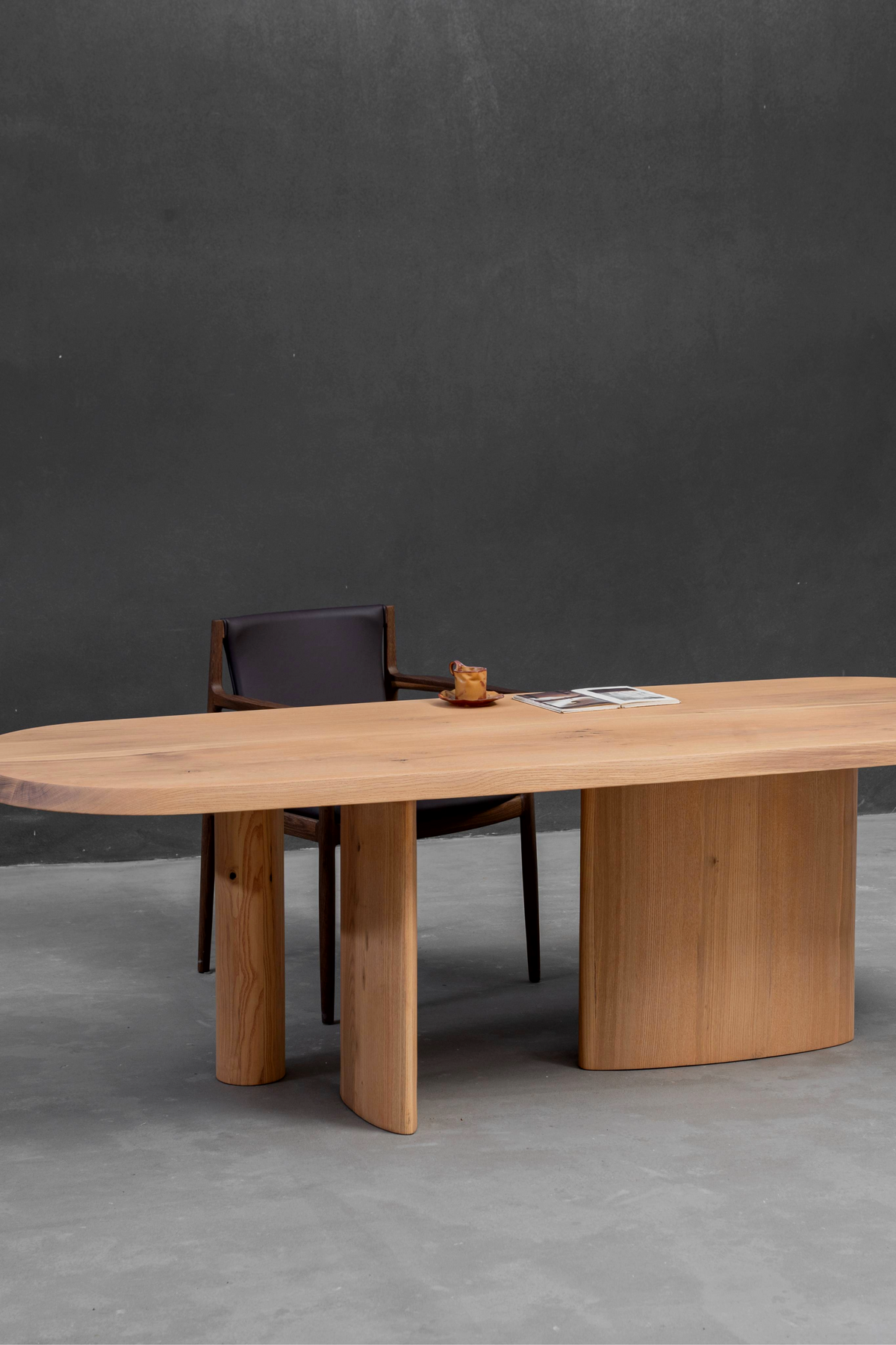 Angled side view of Fusion Table in minimalist interior, highlighting its light wood tones and clean lines.