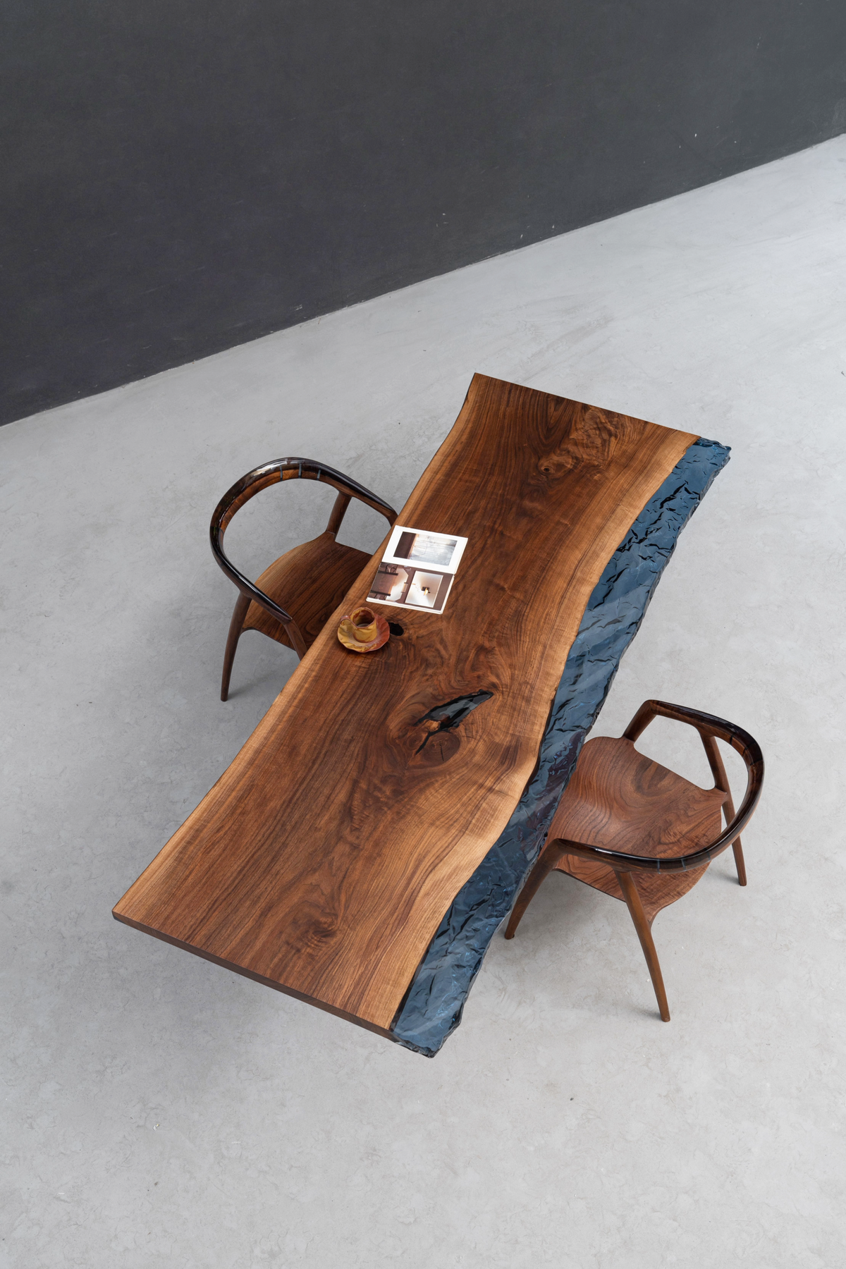 Overhead angle of New World Table with two chairs, showcasing blue ocean epoxy and black walnut live edge.