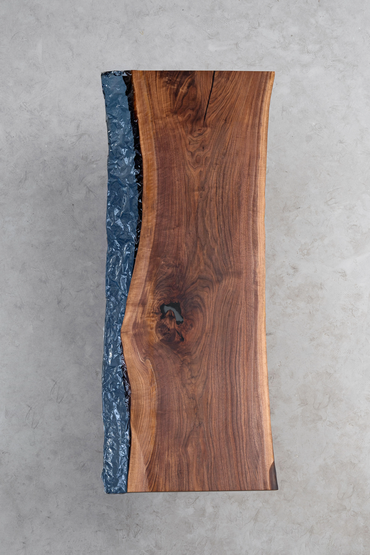 Direct overhead view of the New World Table slab, showcasing the full blue ocean epoxy ocean along black walnut