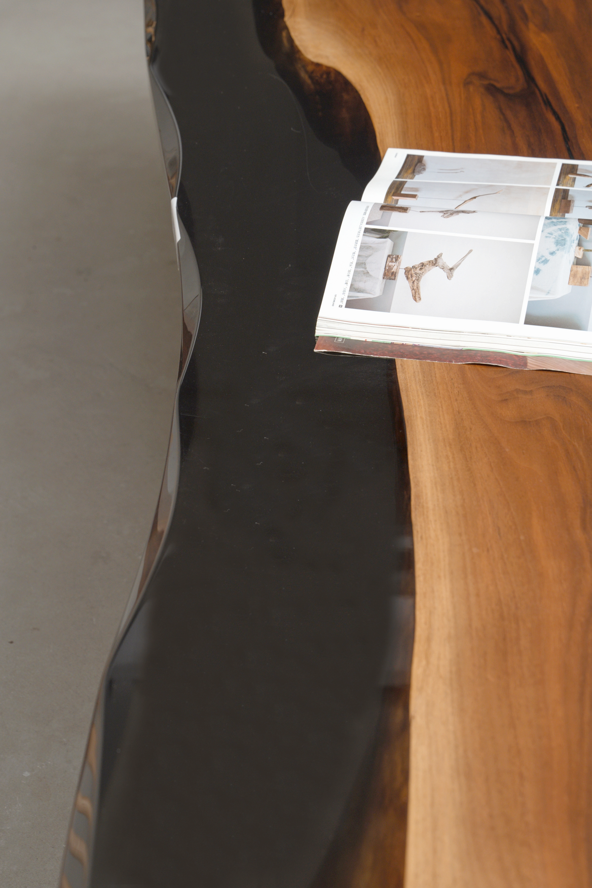 Close-up of the Paradox Table's live-edge walnut surface beside the glowing epoxy edges.