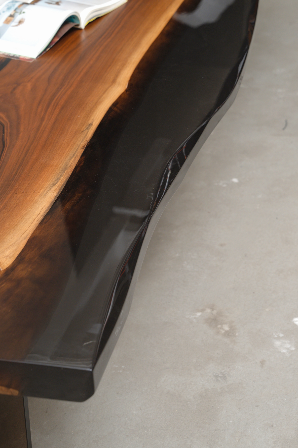 Close-up detail of the Paradox Table's handcrafted black ice epoxy edges, showcasing the resin and wood fusion.