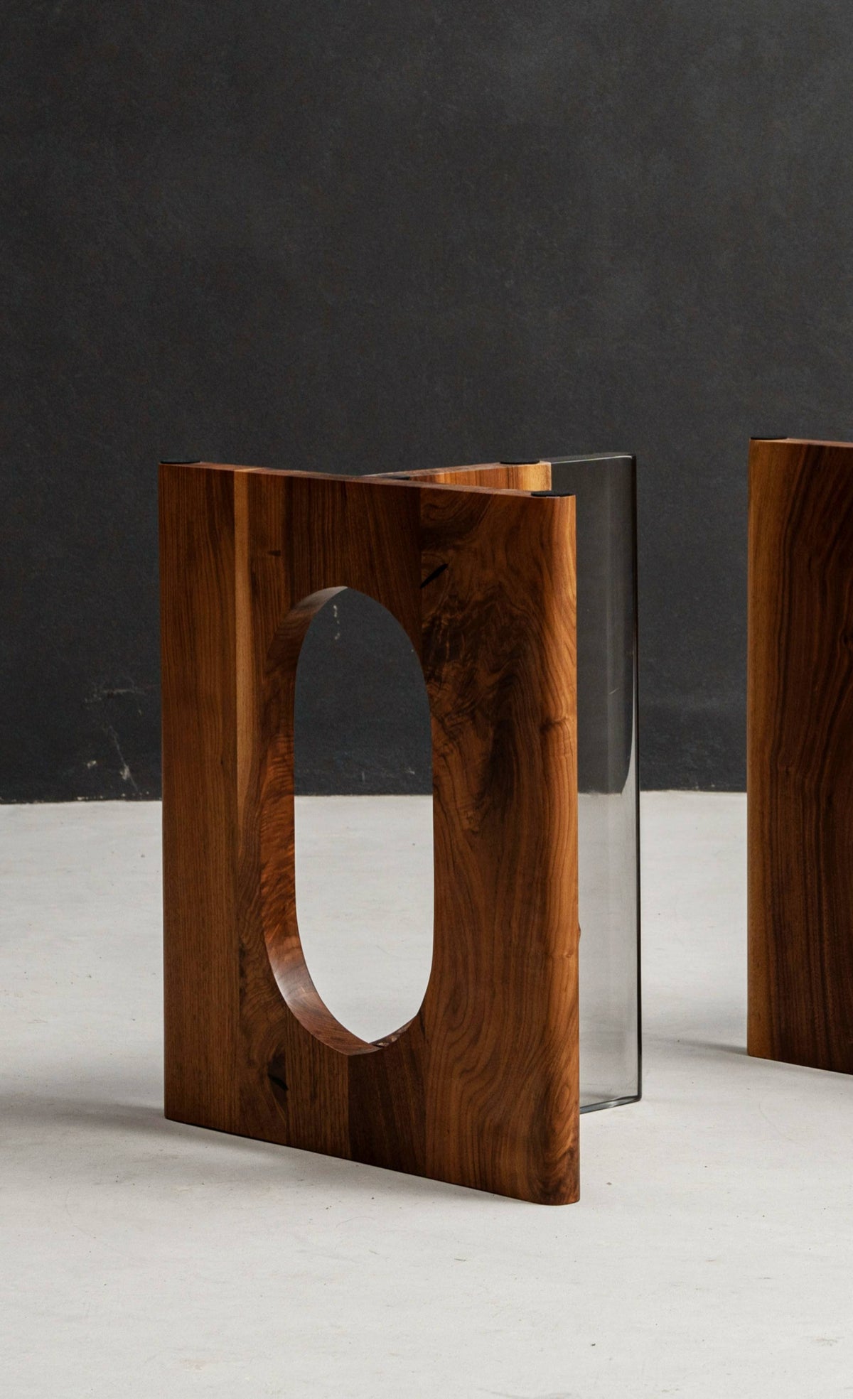Architectural black walnut table base with sculptural design, shown from an alternate angle to reveal balance and structure.