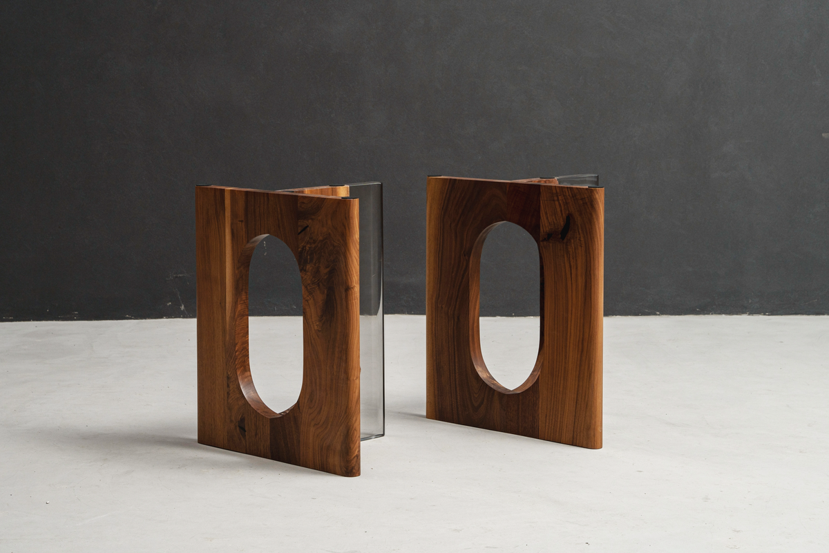 Two Symposium bases side by side on minimal background, highlighting symmetrical black walnut forms.