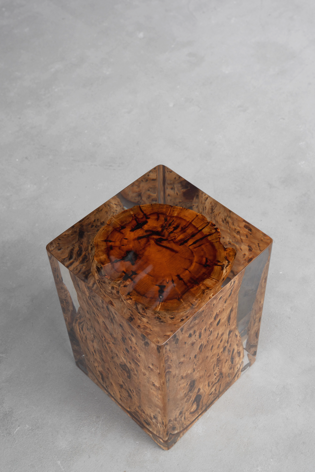 Close-up of rectangular camphor wood root stool with geometric resin edge details.