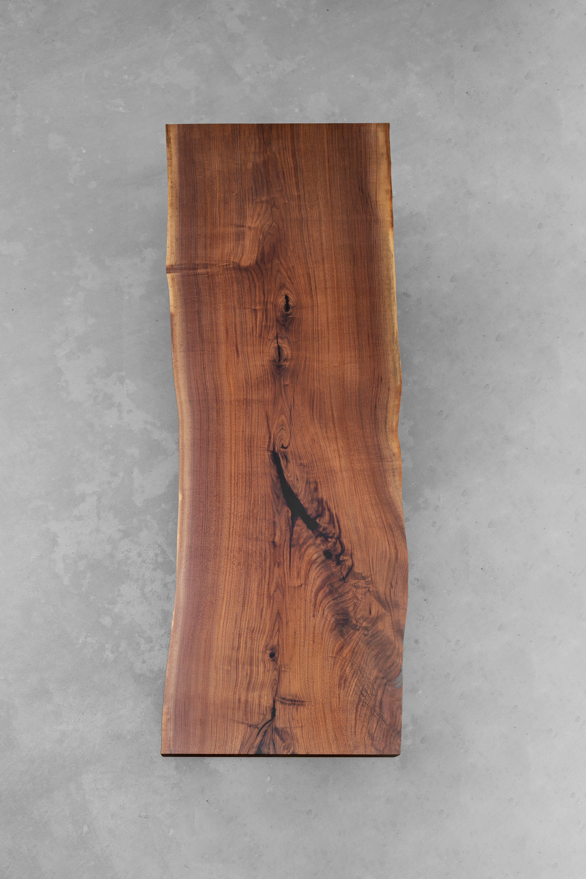 Top-down perspective of the Span of Influence Table, highlighting the dramatic grain of its North American black walnut slab.