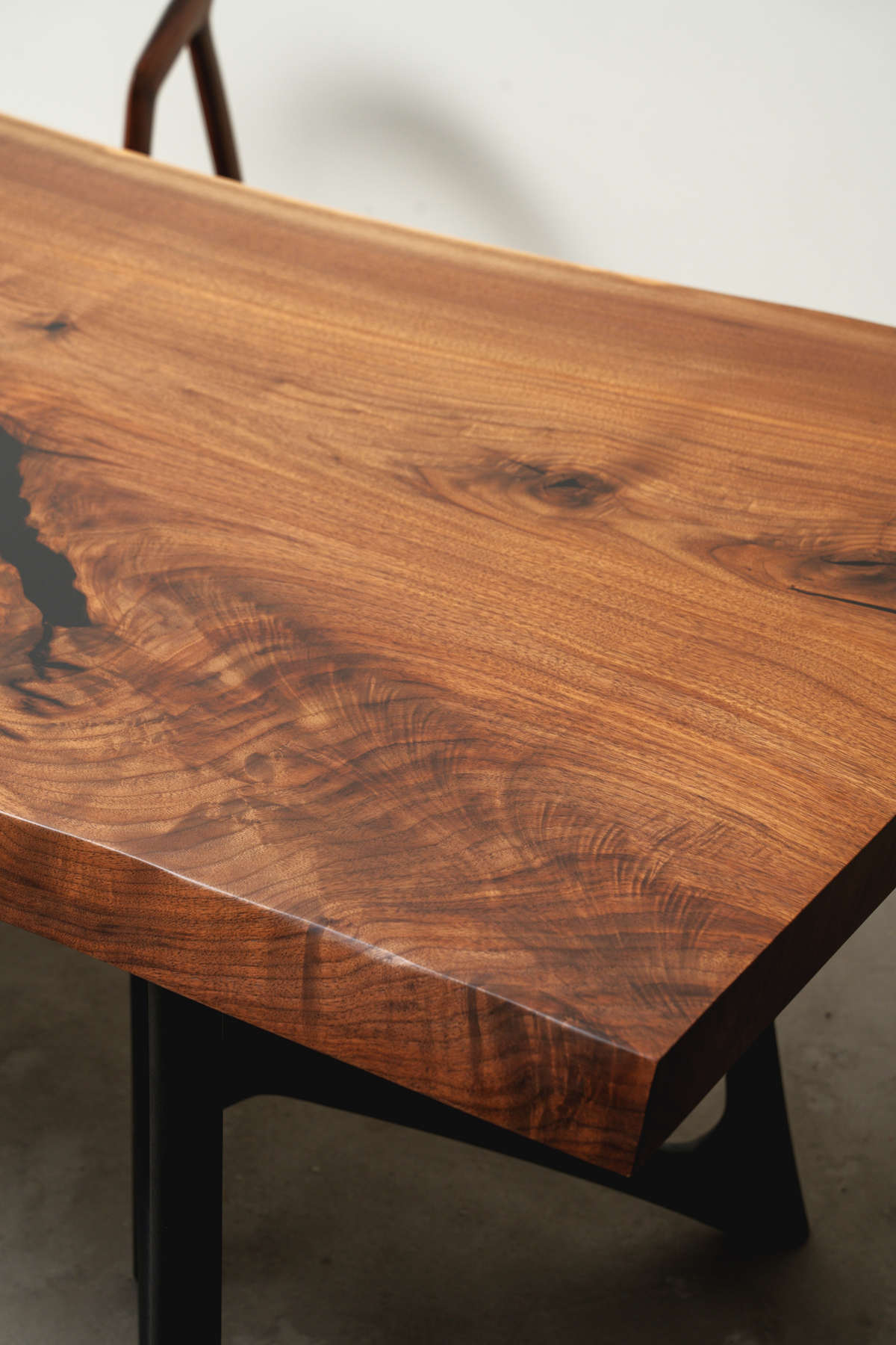 Detailed shot of the Span of Influence's live edge, revealing the preserved natural form of the black walnut slab.
